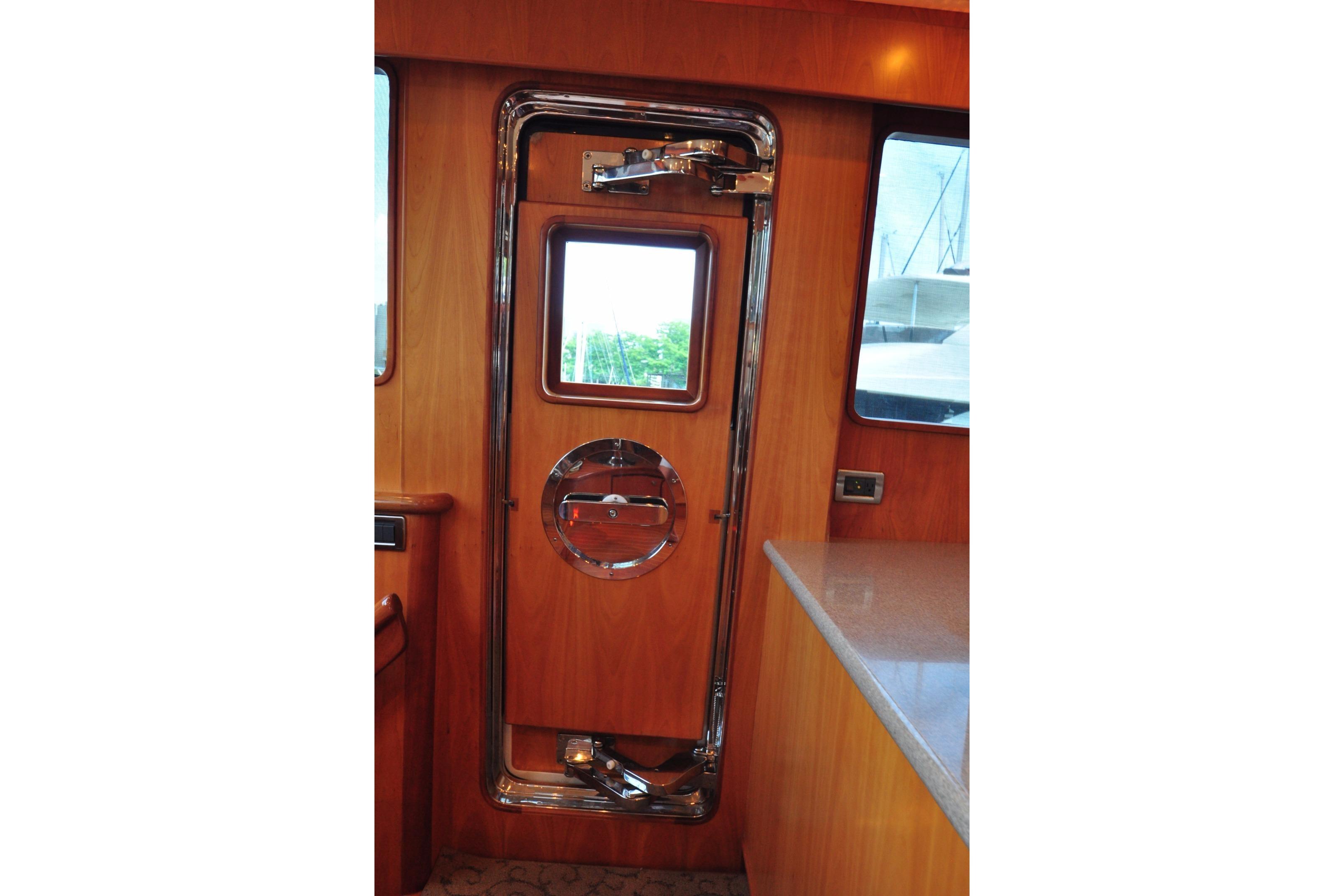 Wooden yacht interior with chrome-accented door, Symbol 56, 2003 model.