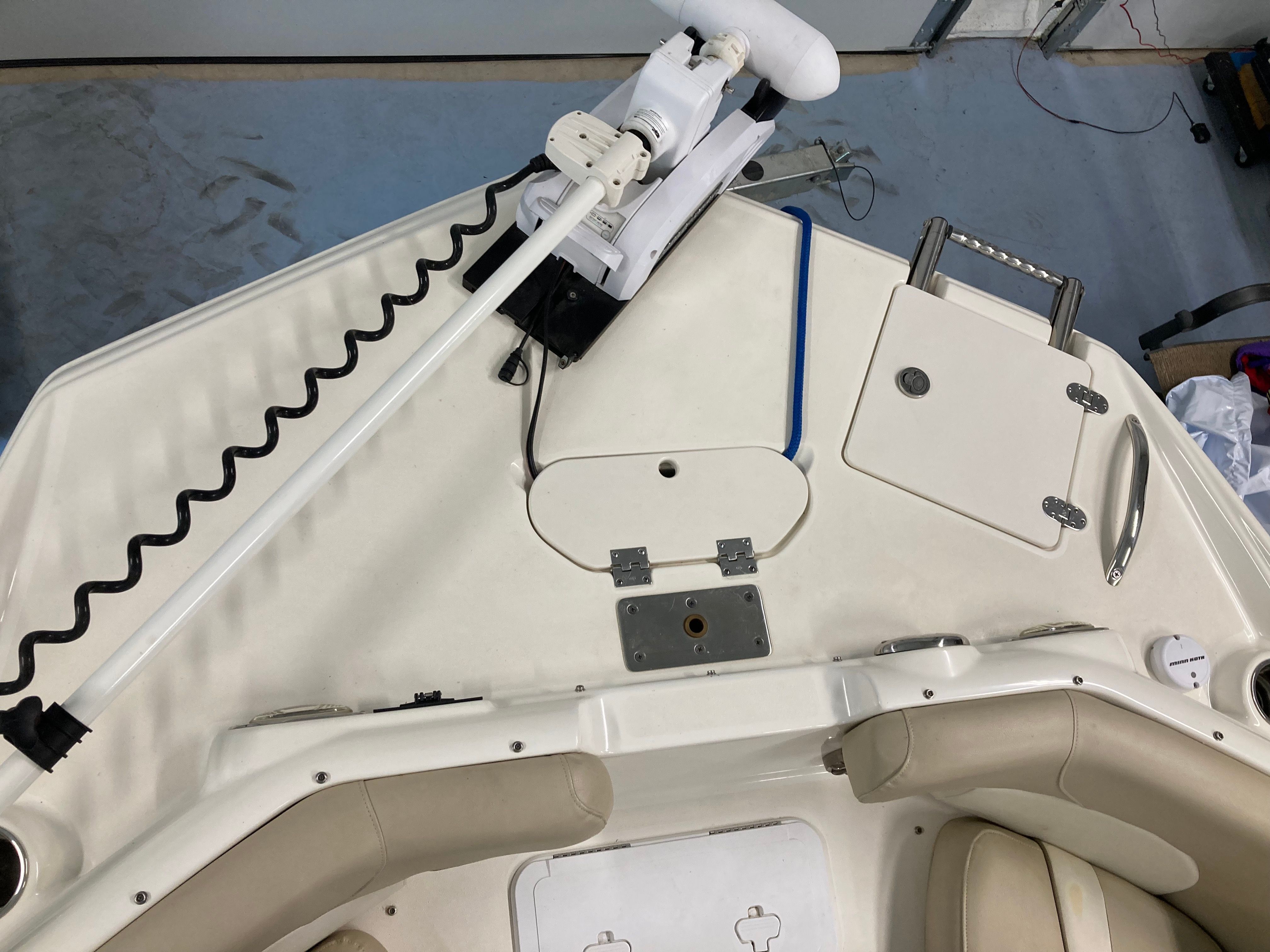 Top view of a boat deck with seating and a mounted motor.