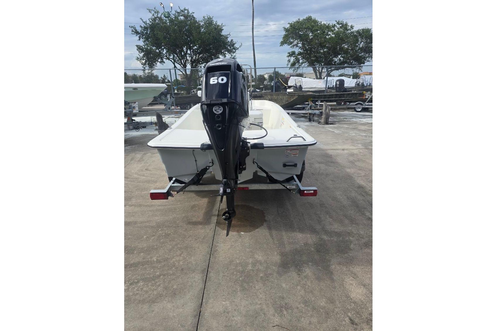 2026 Mako Pro Skiff 15 CC boat with 60 HP outboard motor on trailer.