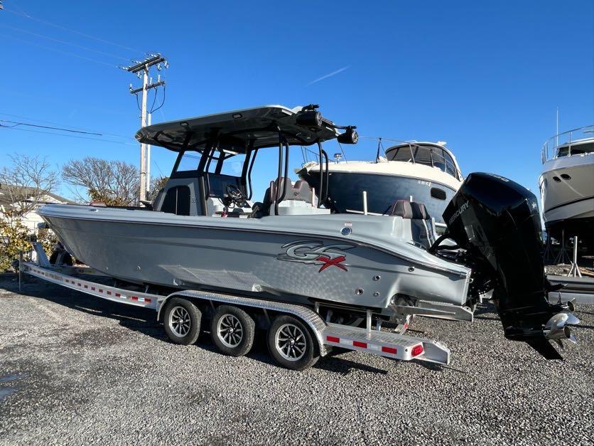 2024 Glasstream 32 GSX boat on trailer, parked outdoors under clear blue sky.