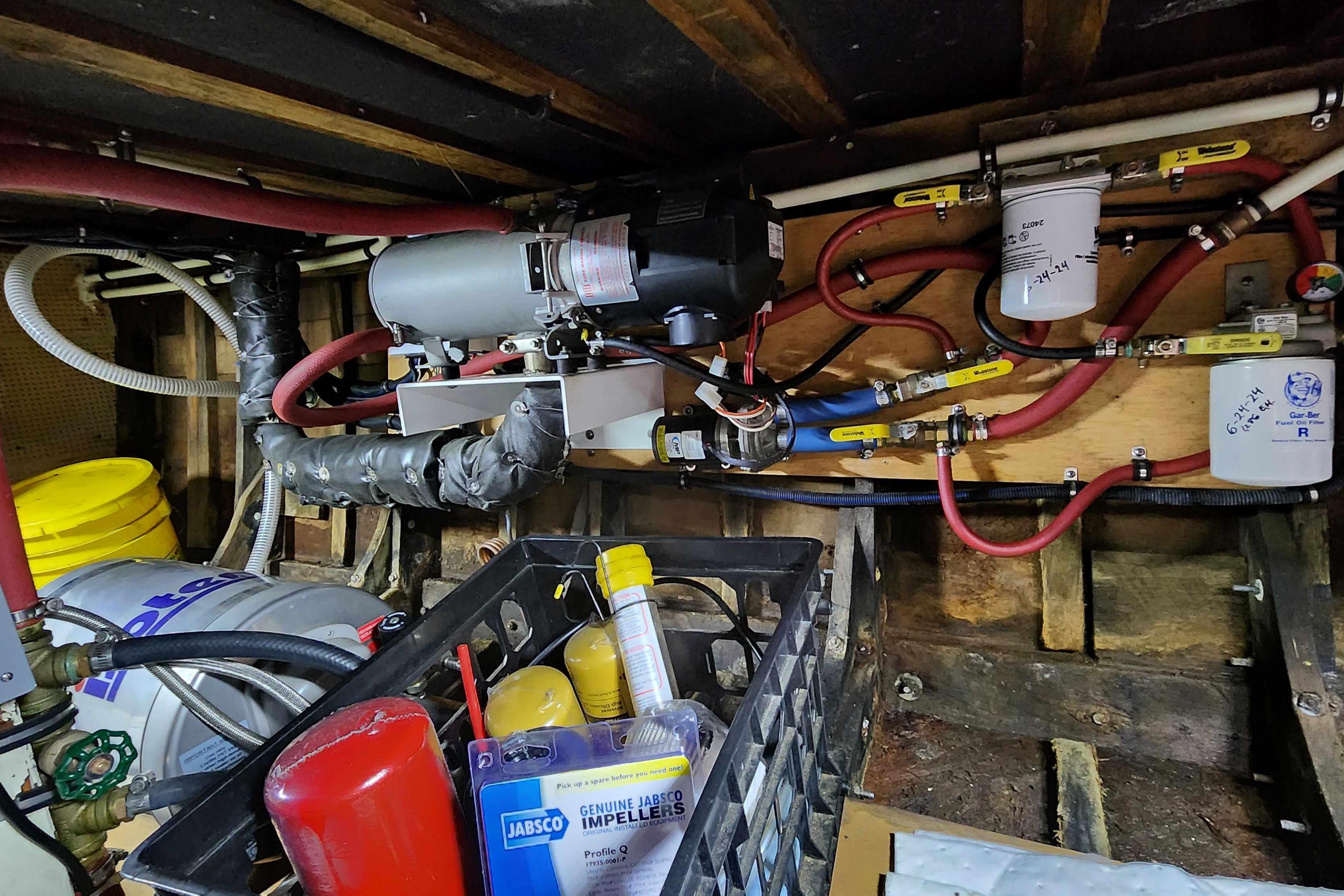 Engine room of a 1964 Grandy Tour Boat with mechanical components and tools.