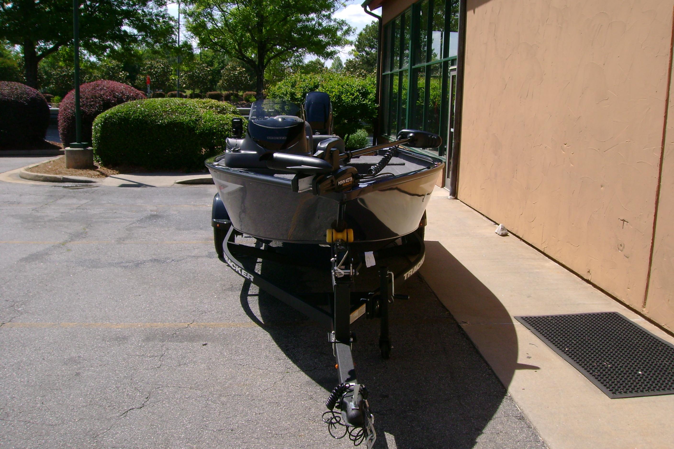 2026 Tracker Super Guide V-16 SC boat parked outside a building.