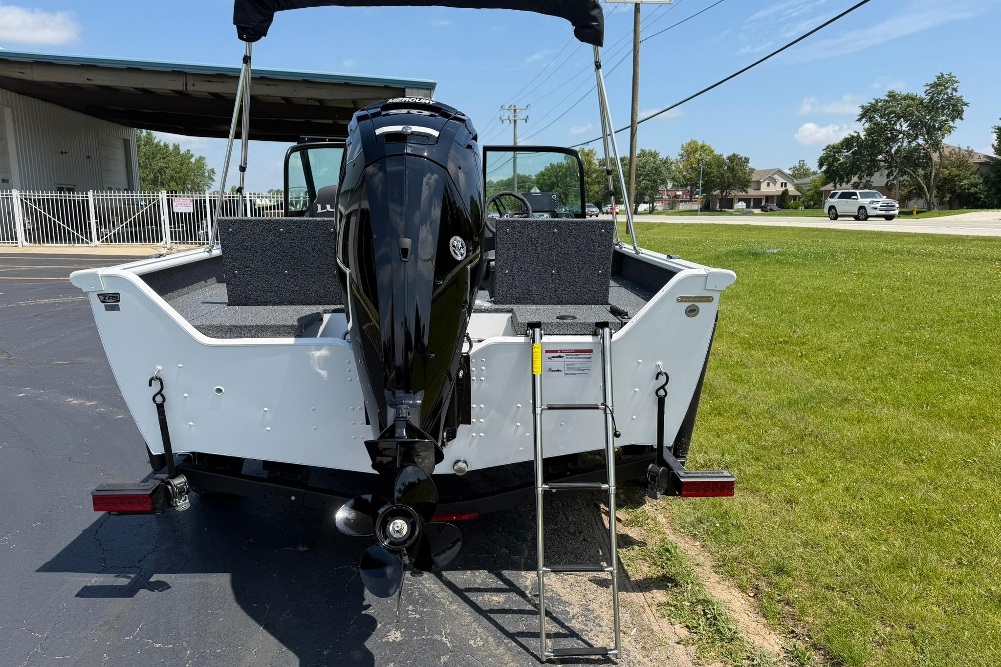 2027 Lund 1675 Adventure Sport boat with Mercury engine, parked outdoors on a sunny day.