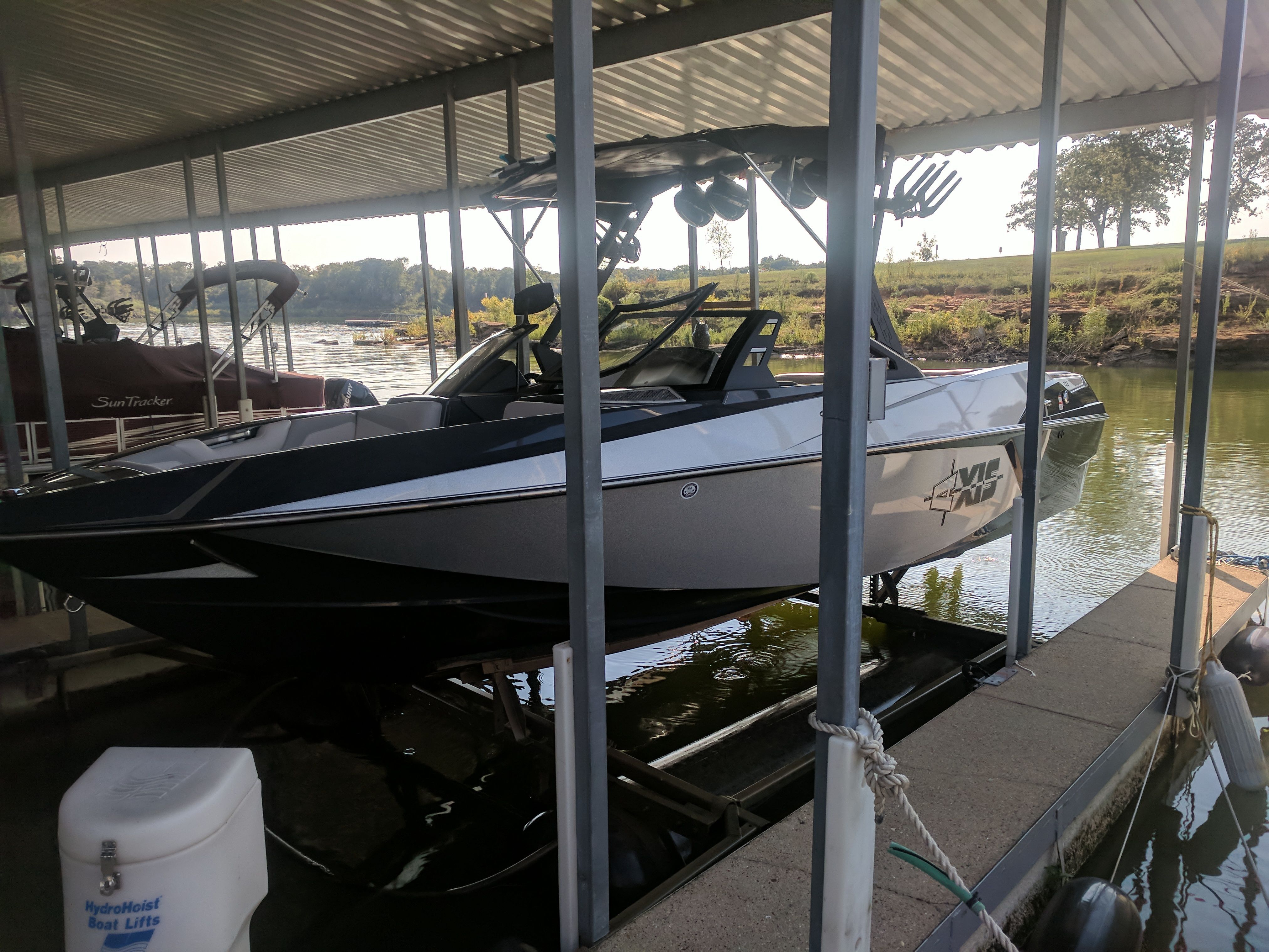 A 2017 Axis T23 is docked in a covered slip on the water.