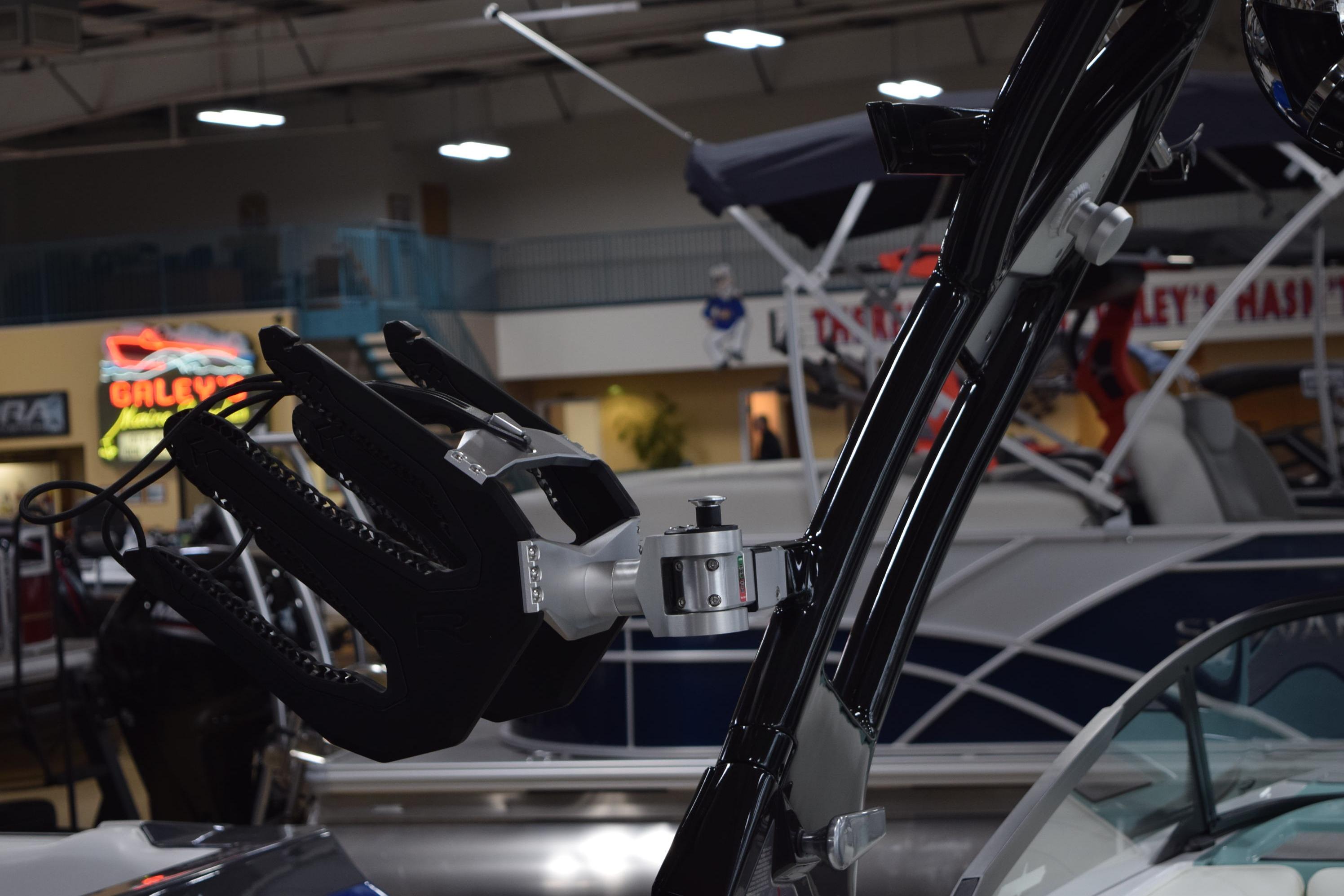 2025 Moomba Mojo boat with advanced wakeboard tower in showroom setting.