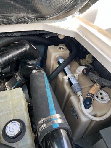 Engine compartment of 2001 Sea Ray 340 Sundancer with hoses and tanks.