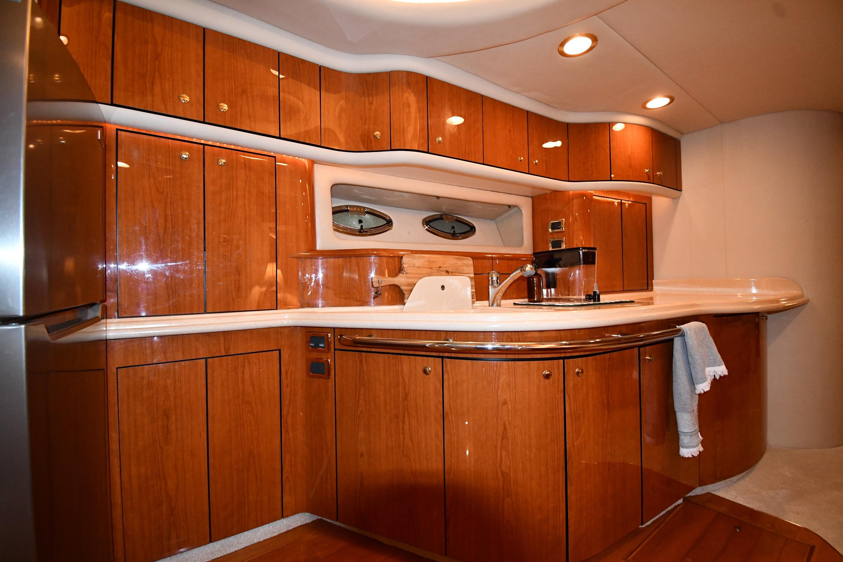 Luxurious 2001 Sea Ray 540 Sundancer yacht interior with elegant wooden cabinetry and modern amenities.