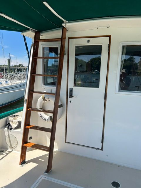 1980 Grand Banks 32 Sedan with wooden ladder and door.