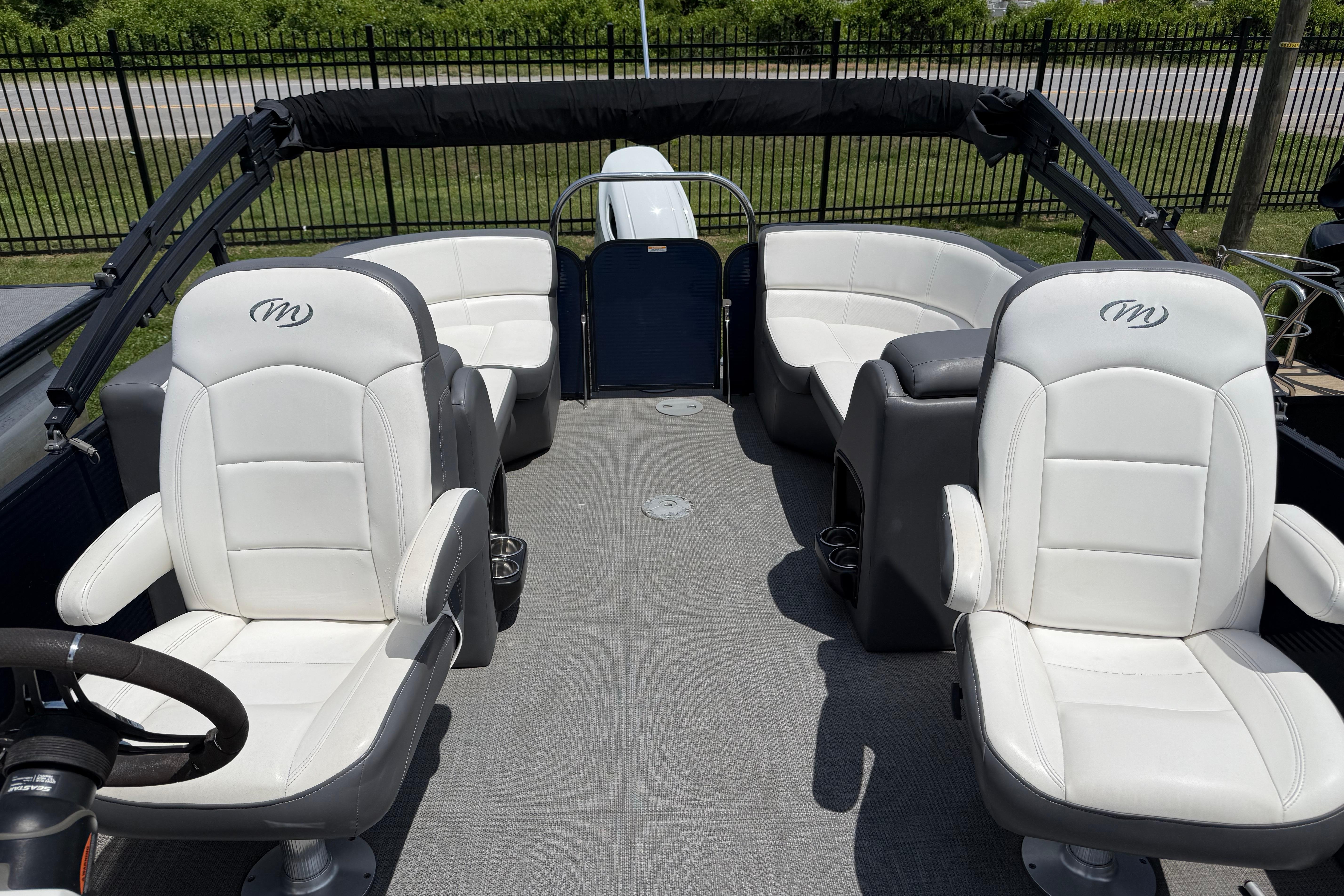 2022 Manitou Aurora LE boat interior with white seating and gray flooring.