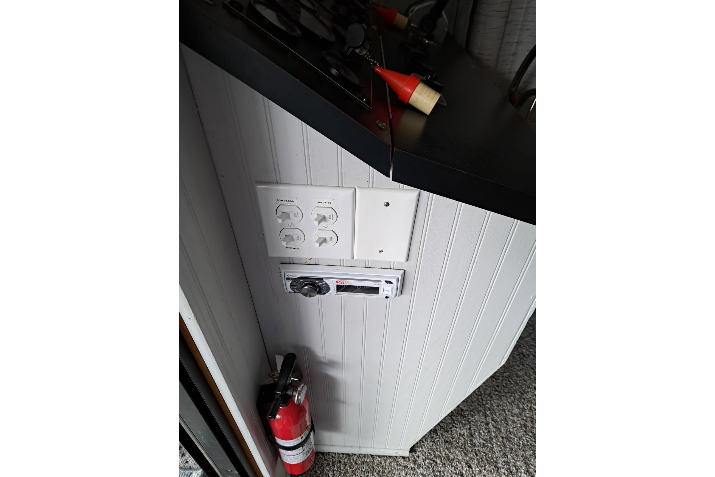 Control panel and fire extinguisher on 1990 Sumerset 16 x 70 houseboat interior.