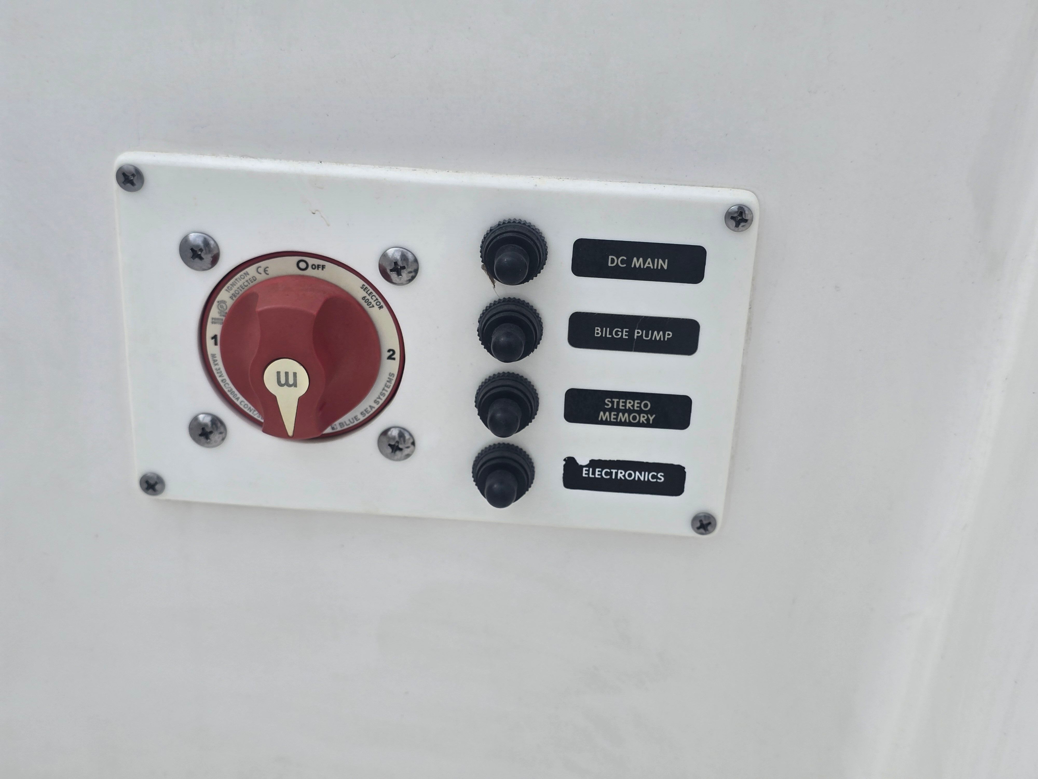 Control panel with a main switch and four toggle switches for various boat functions.