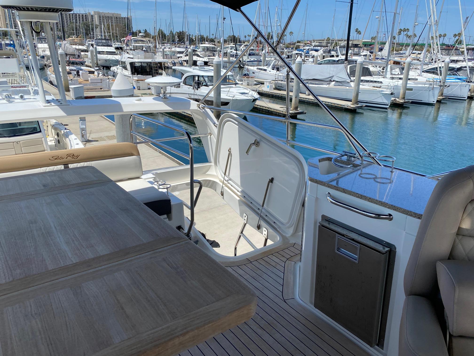 2018 Sea Ray 400 Fly yacht interior with marina view, featuring seating and table.