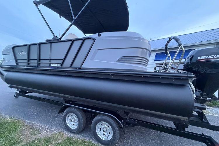 2026 SunChaser Lucerne 22 LR DH Sport pontoon boat on trailer with Mercury outboard motor.