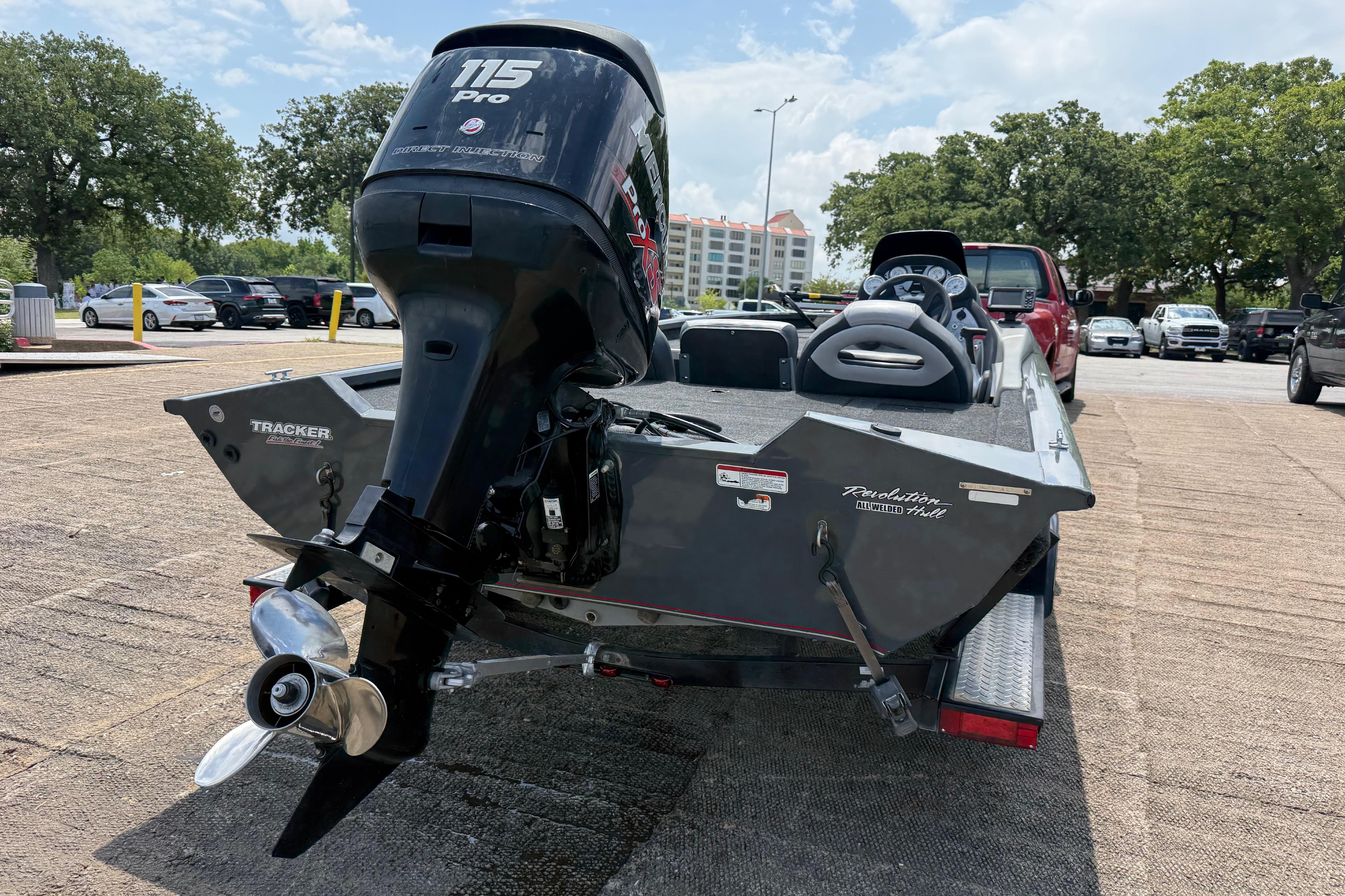 2015 Tracker Pro Team 190 TX boat with 115 Pro outboard motor in parking lot.