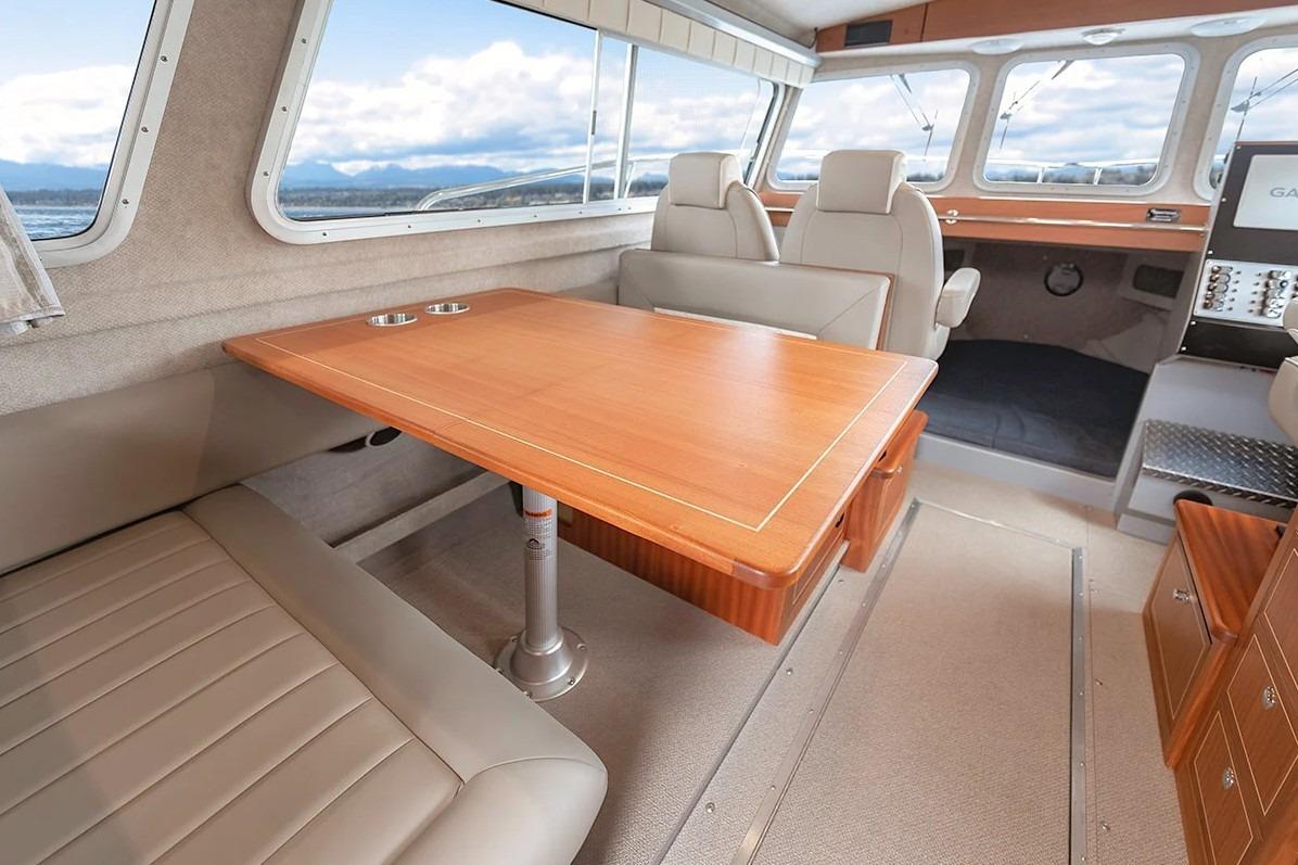 Interior of 2026 KingFisher 3225 GFX Offshore boat with seating and wooden table.