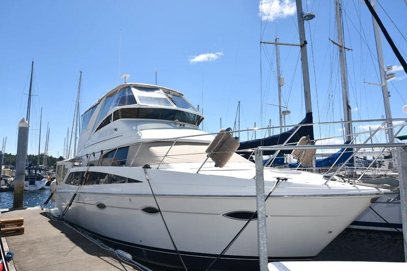 2008 Carver 43 Super Sport yacht docked at marina under clear blue sky.
