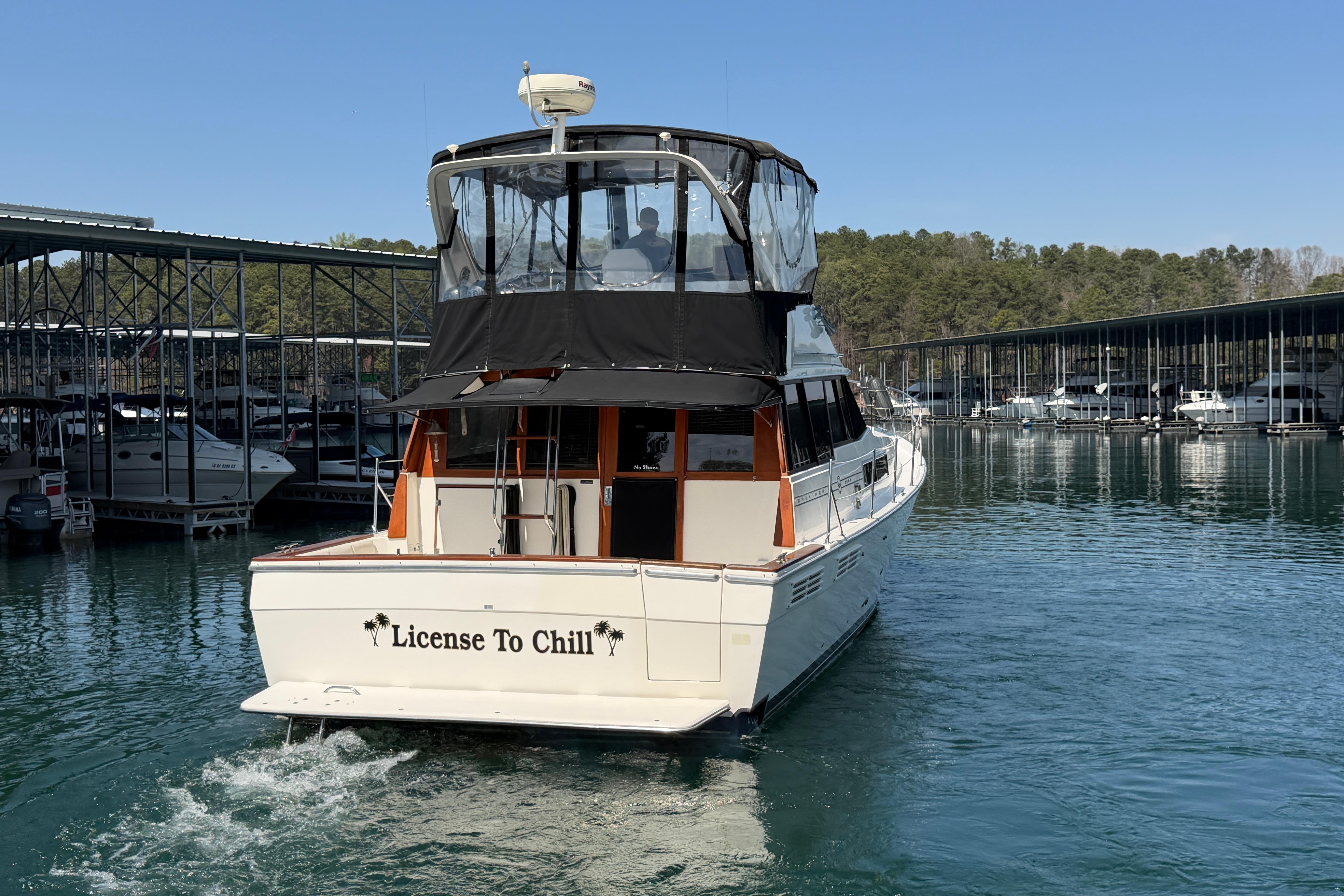 1994 Bayliner 3888 MY Sedan yacht named "License To Chill" cruising in a marina.