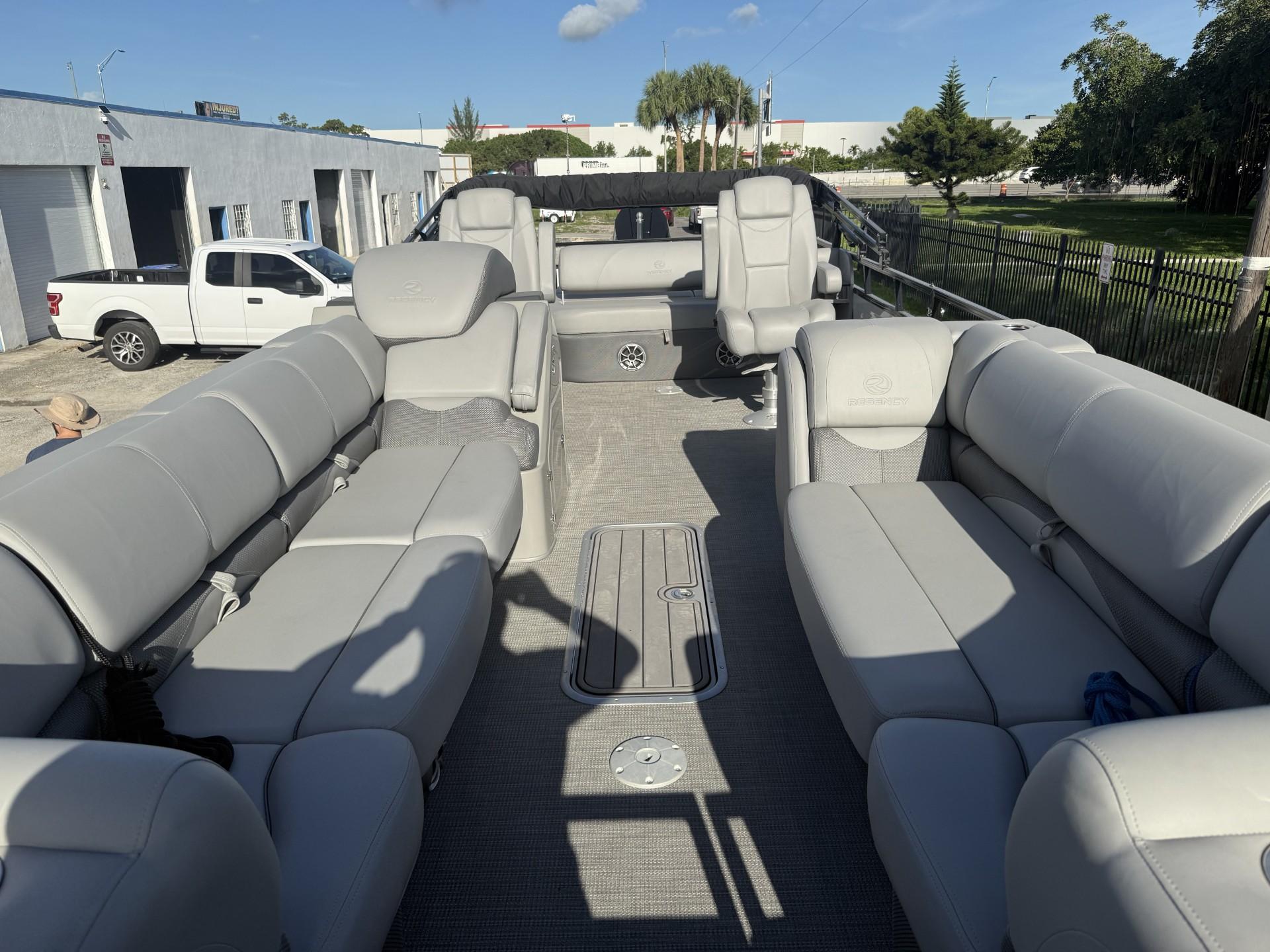 2024 Regency 250 DL3 pontoon boat with spacious gray seating and modern design.
