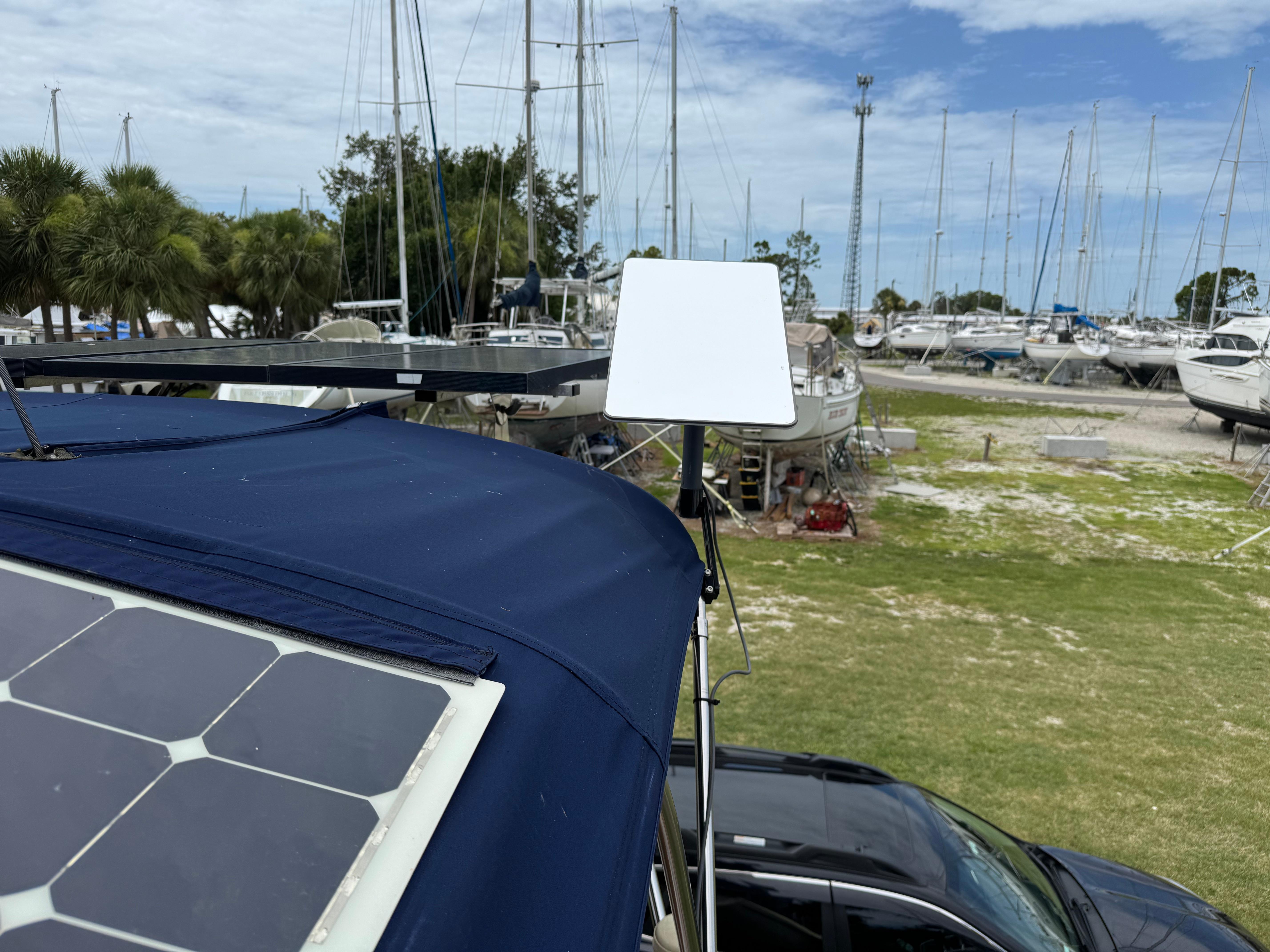 2002 Island Packet 380 with solar panel and satellite dish in a marina setting.