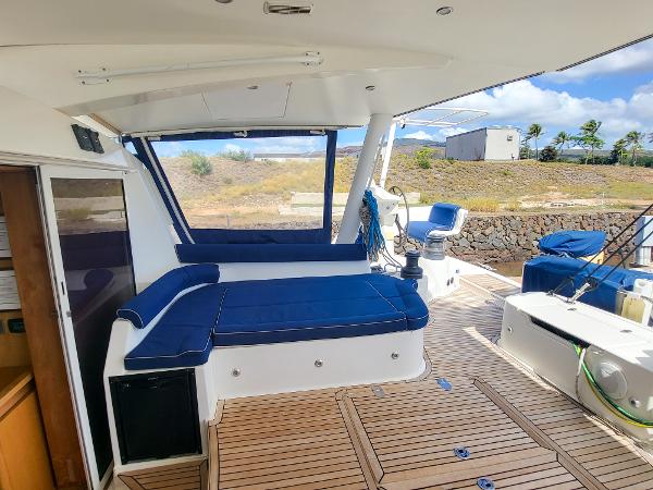 Catana 65 2009 yacht deck with blue seating and wooden flooring.