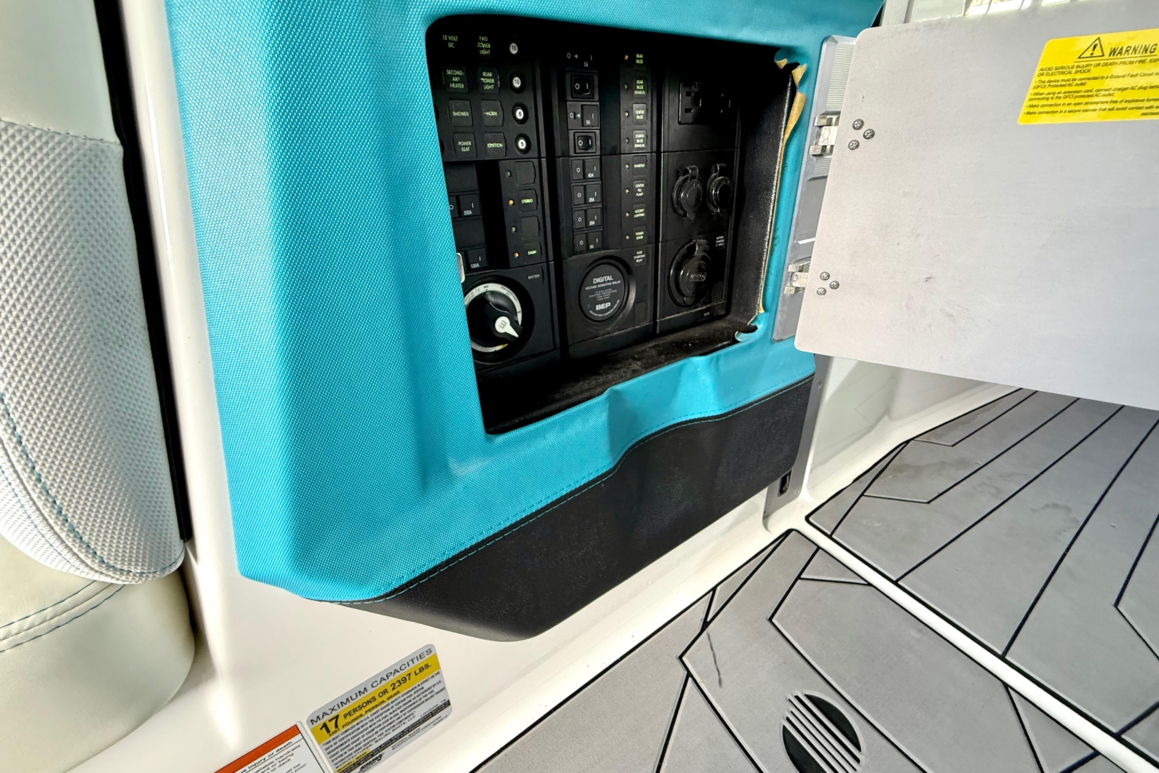 Control panel inside a 2017 Malibu M235 boat with blue trim and warning labels.