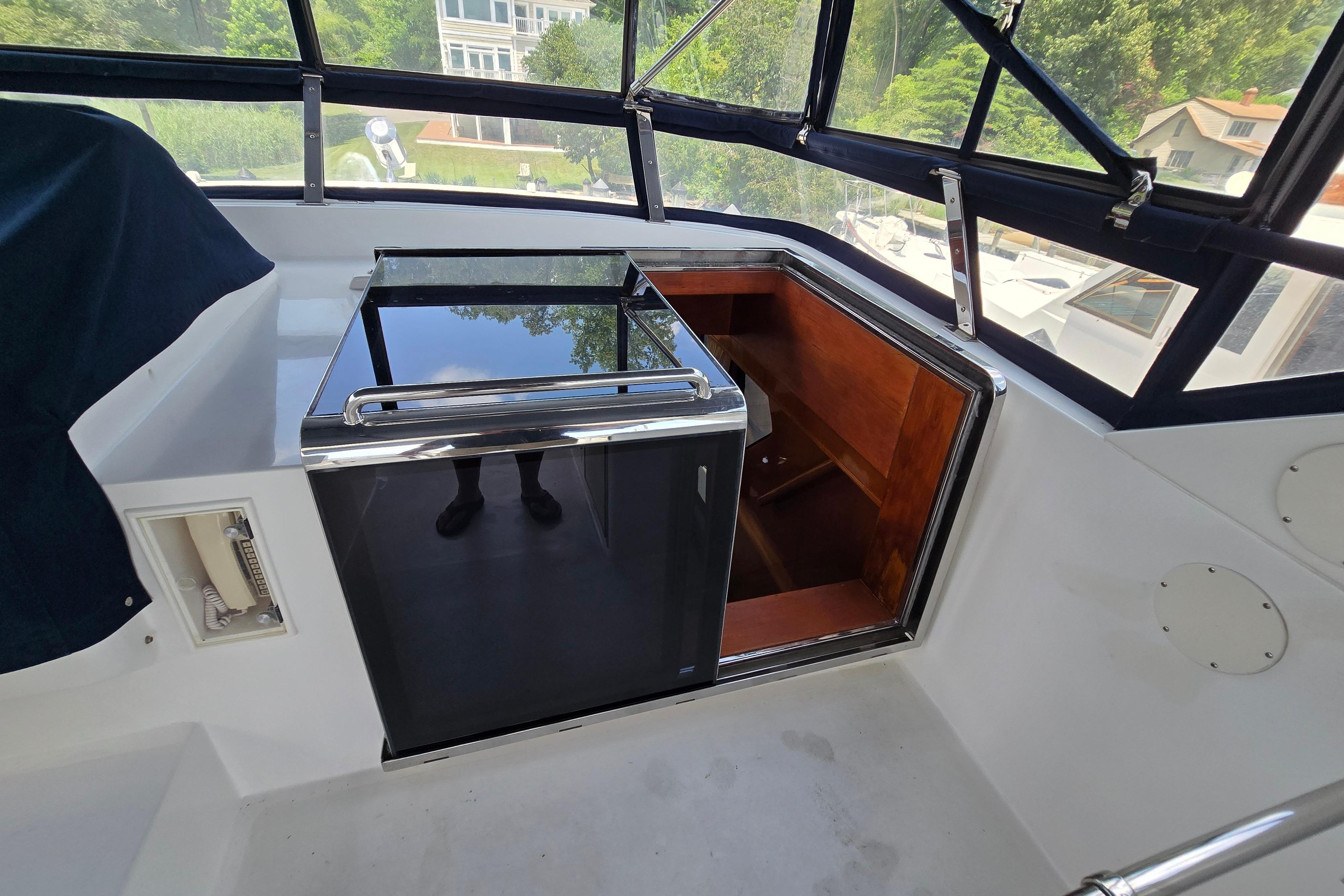 Interior view of a 2004 Grand Harbour 58 yacht with a mini fridge and wooden storage.