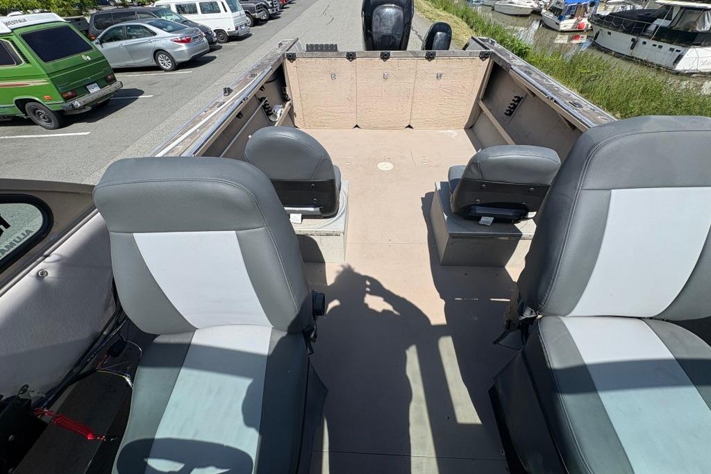 2009 Alumaweld Intruder Outboard 22 interior with seating, parked near marina.
