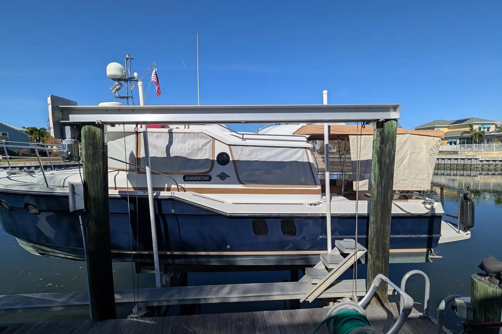 2015 Ranger Tugs R-29 S boat docked at marina under clear blue sky.