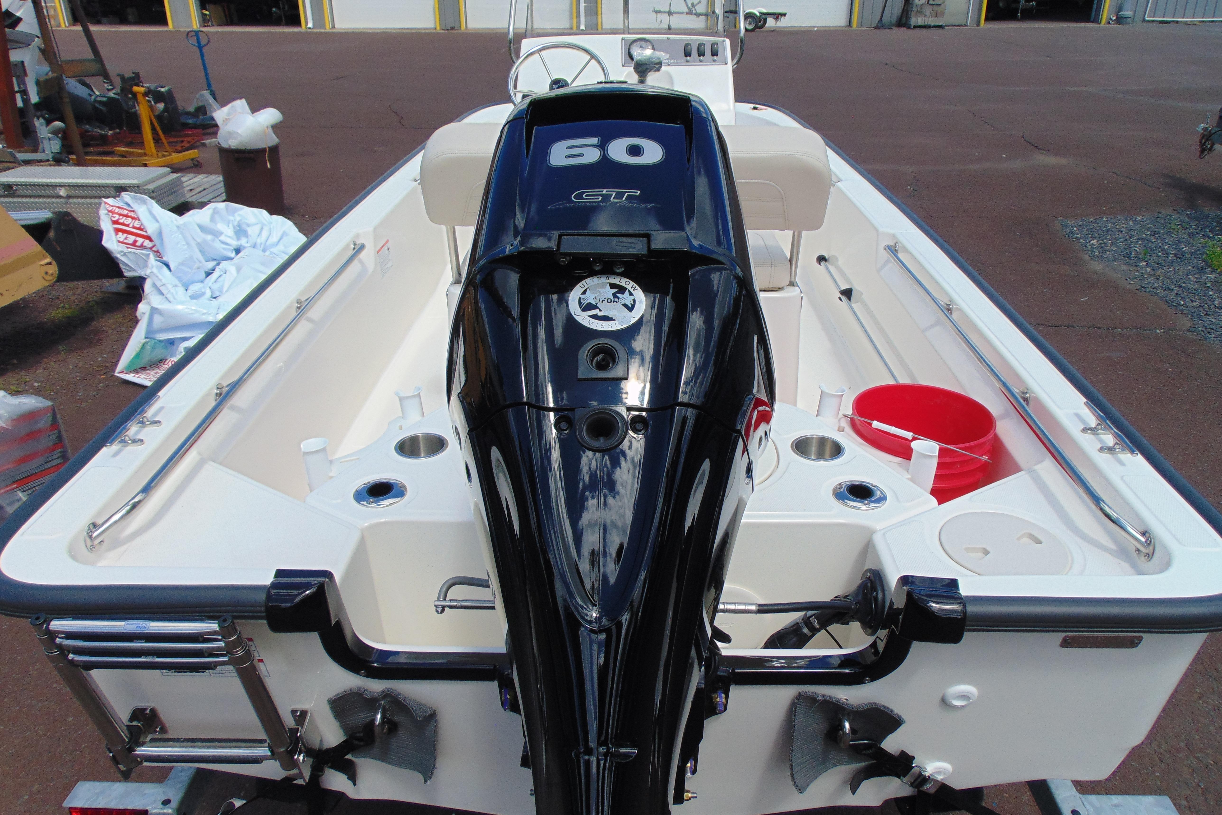 2026 Boston Whaler 150 Montauk boat with powerful outboard motor, docked outdoors.