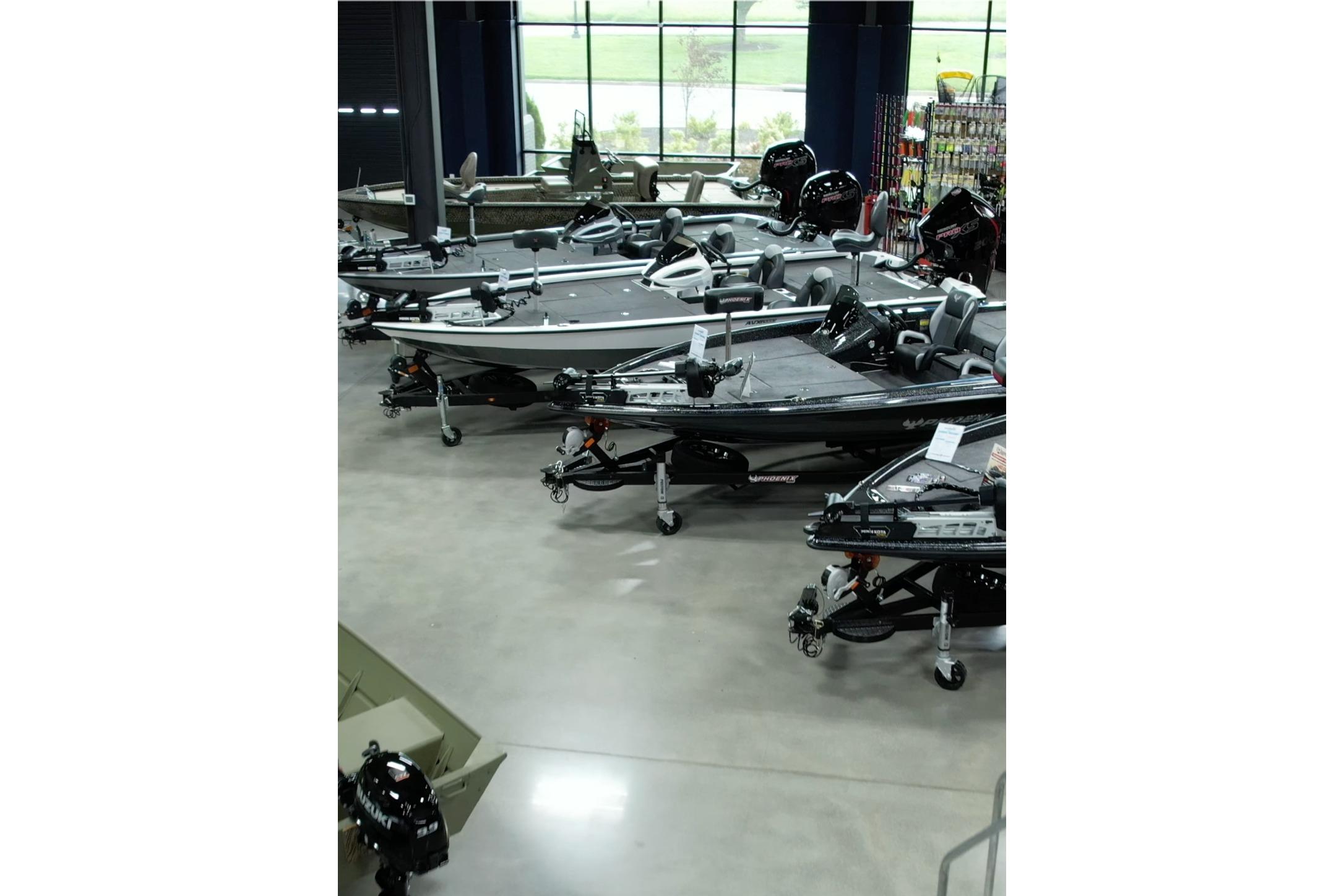 Showroom displaying multiple iKon LXL20 boats, 2026 model, on polished concrete floor.