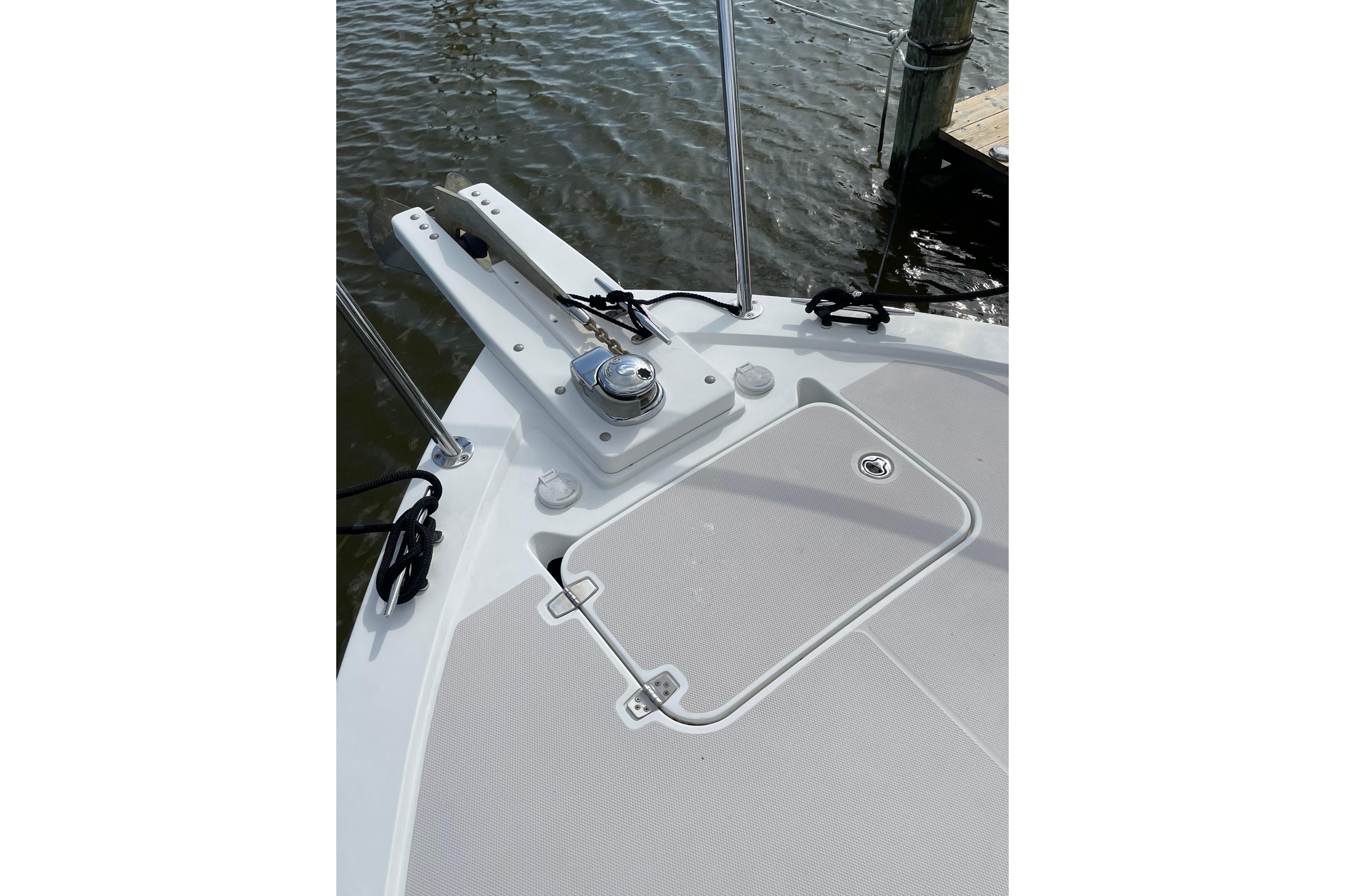 2007 Back Cove 29 boat deck with anchor and hatch, docked by the water.
