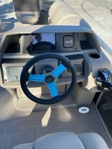 2024 Sun Tracker Fishin' Barge 20 DLX steering console with blue-accented wheel.
