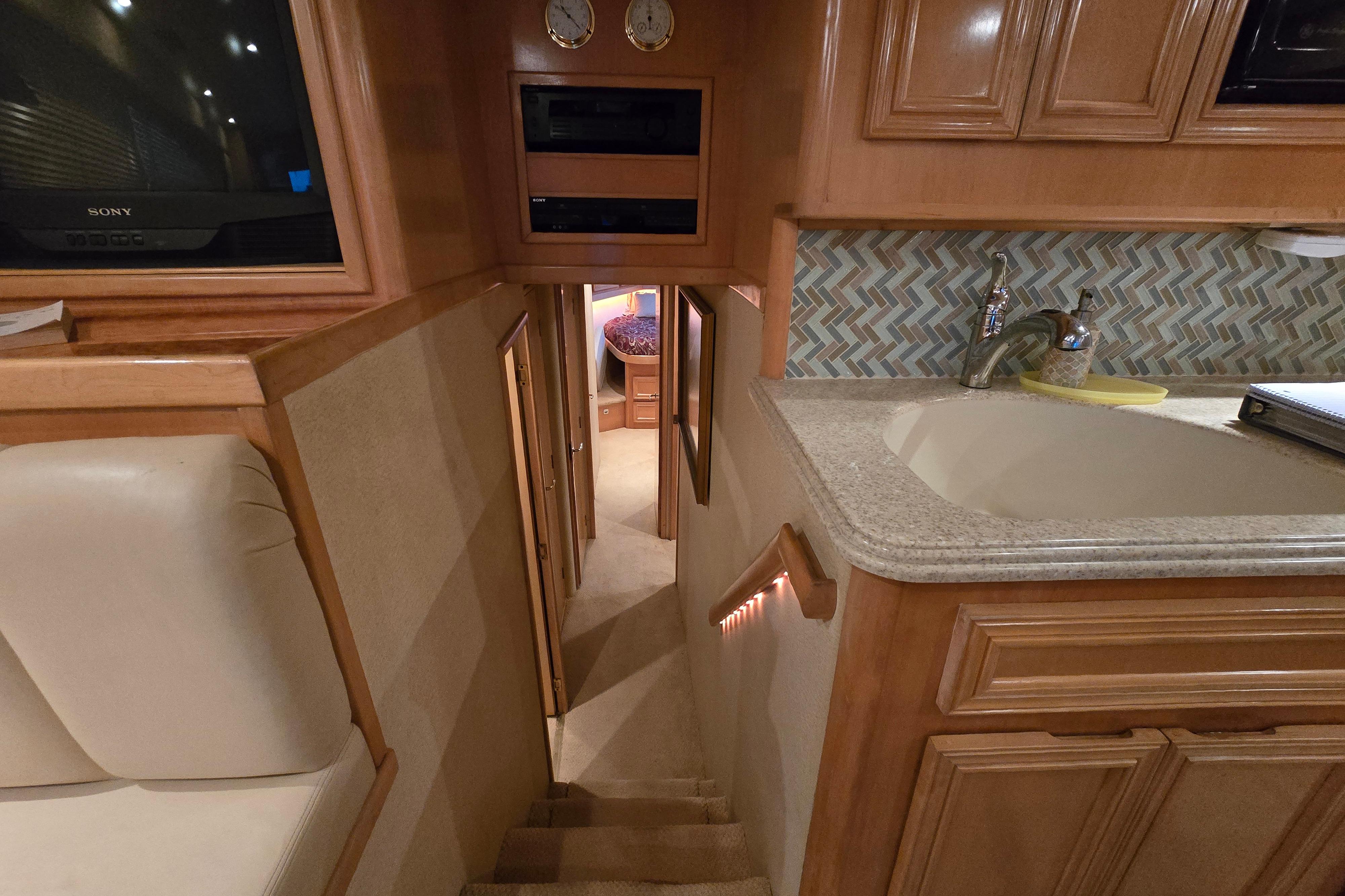 Interior of 2001 Cavileer 53 Convertible yacht with stairs, sink, and cabinetry.