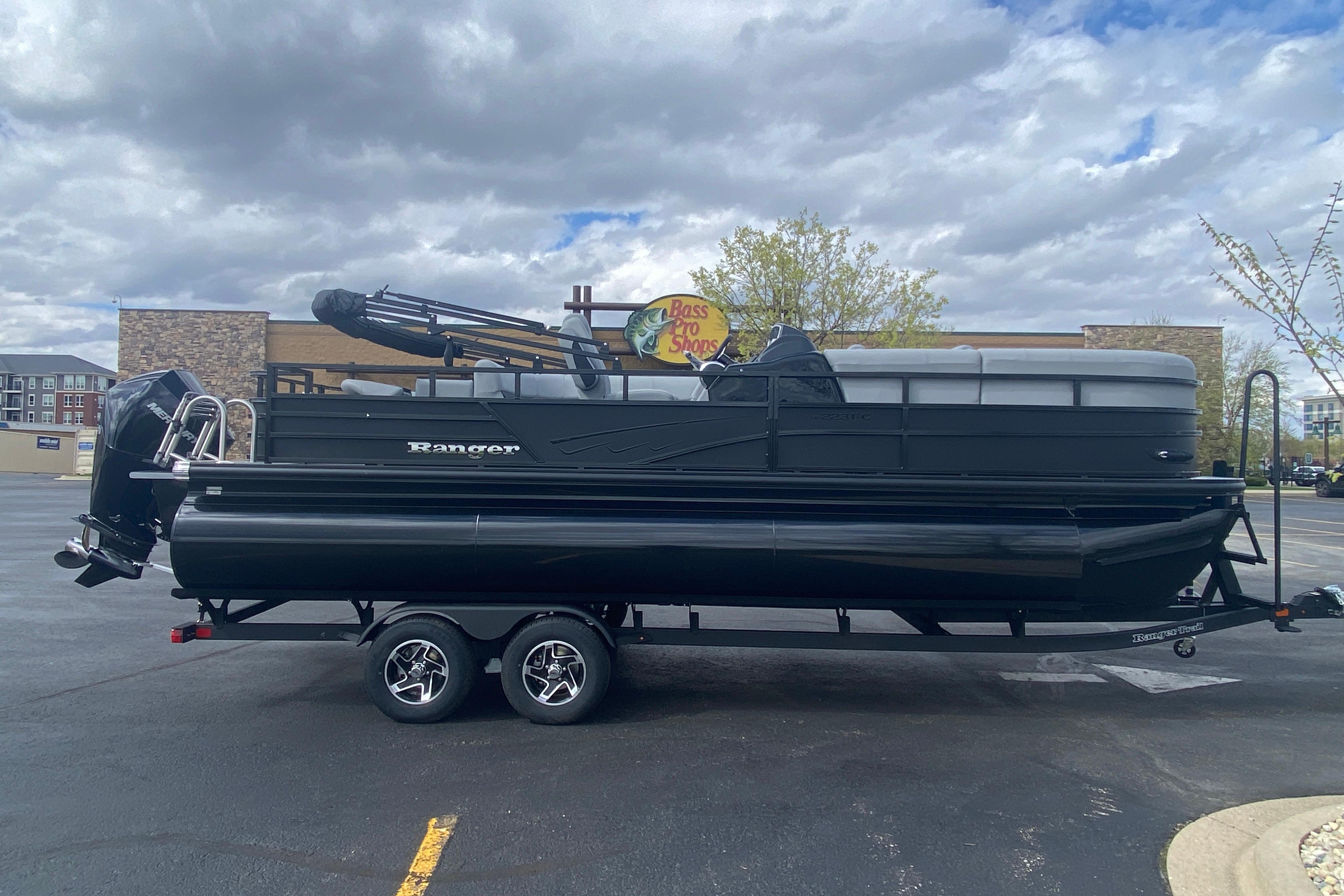 2026 Ranger 223FC pontoon boat on trailer in parking lot, cloudy sky background.