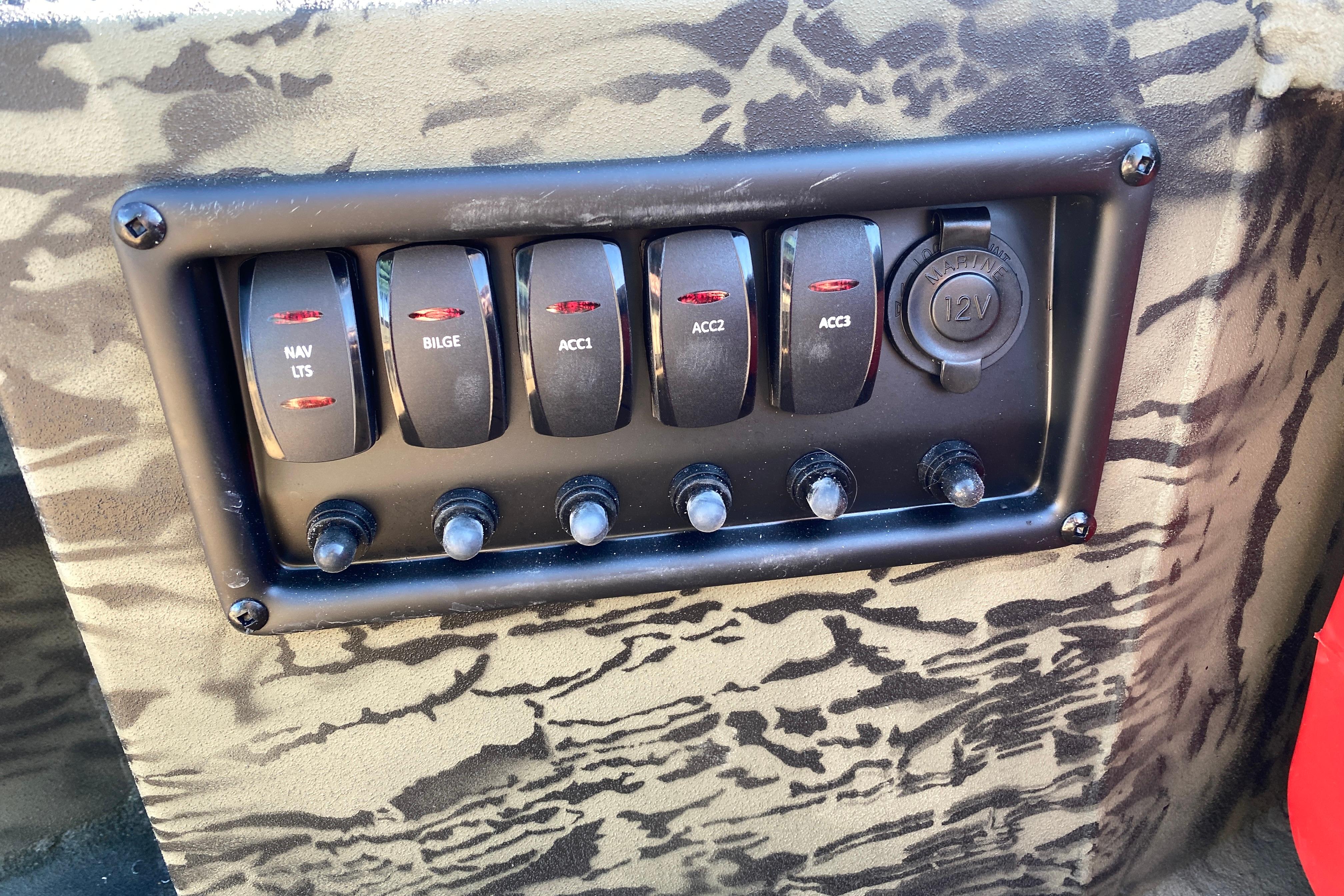 Control panel of 2026 Tracker Grizzly 1650 T Prairie Wings Edition with switches and 12V outlet.