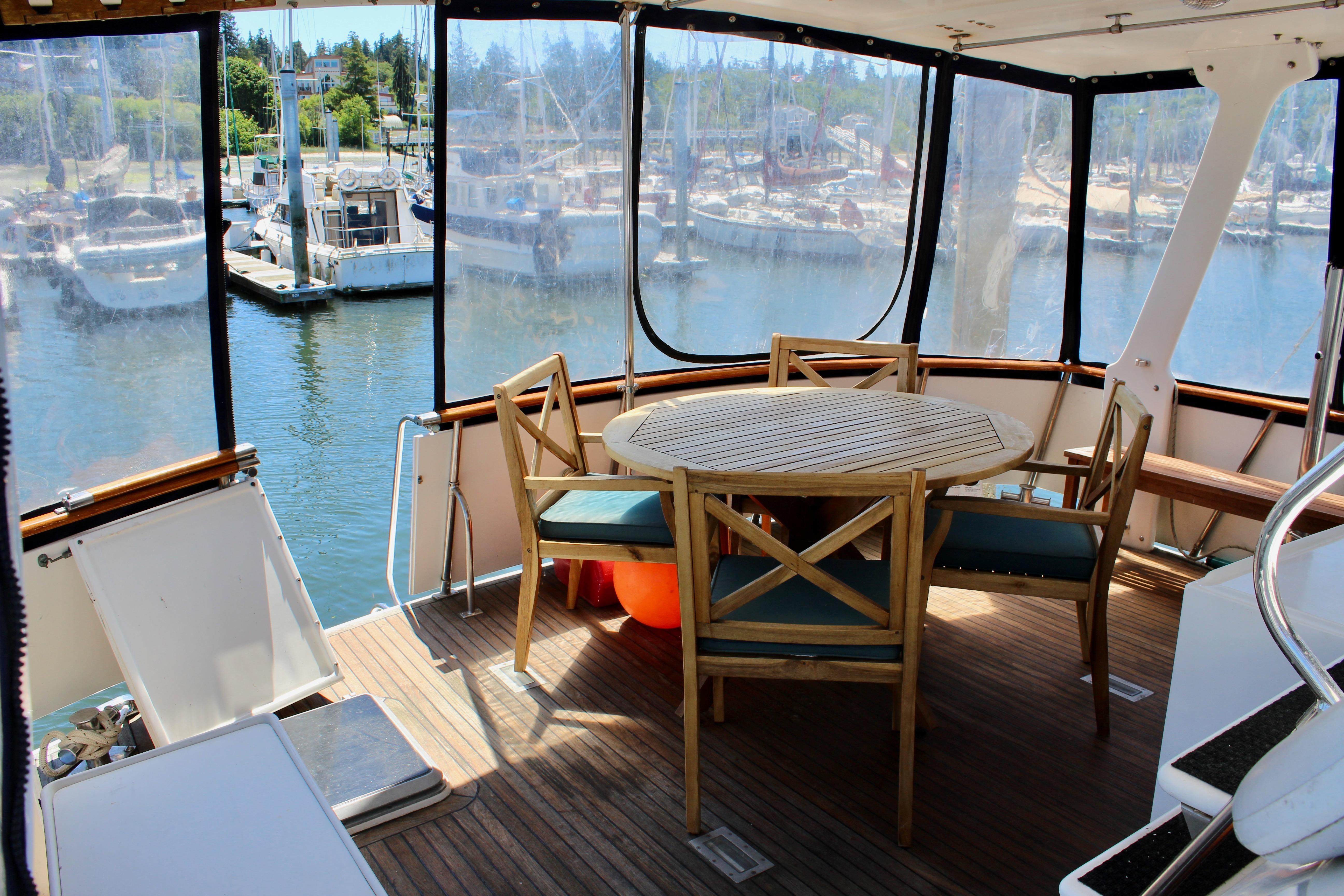 Interior view of 1986 Kha Shing Spindrift 46 yacht with wooden table and chairs.