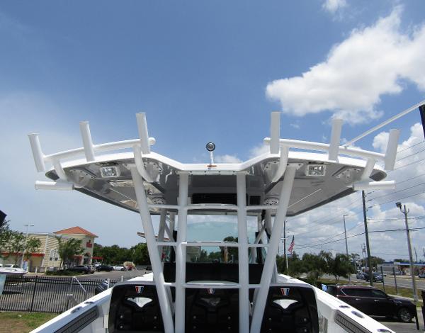 2024 Wellcraft 352 Fisherman boat with T-top and rod holders under a clear sky.
