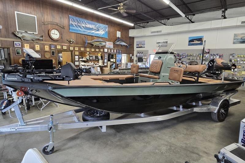 Avid 207 Recon 2026 fishing boat displayed in a showroom with fishing gear.