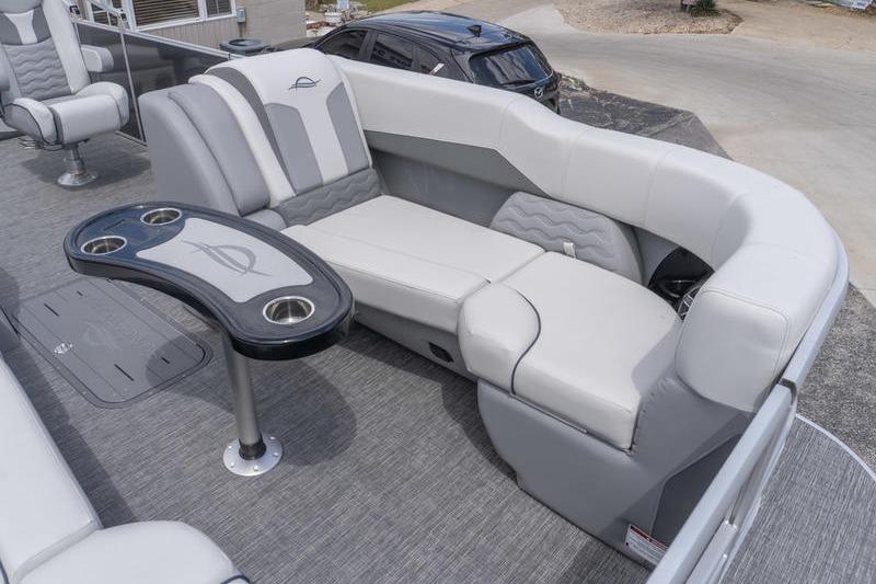 Luxurious seating on 2026 SunCatcher Elite 326 SL pontoon boat with stylish table and cup holders.