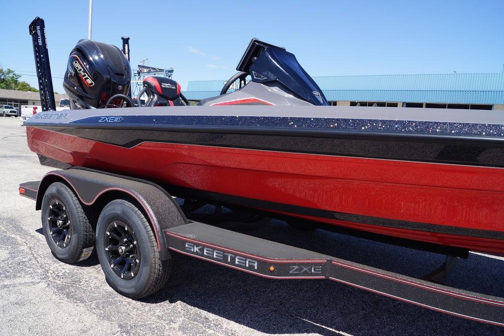 2026 Skeeter ZXE21 boat with red hull on a trailer, featuring a powerful outboard motor.