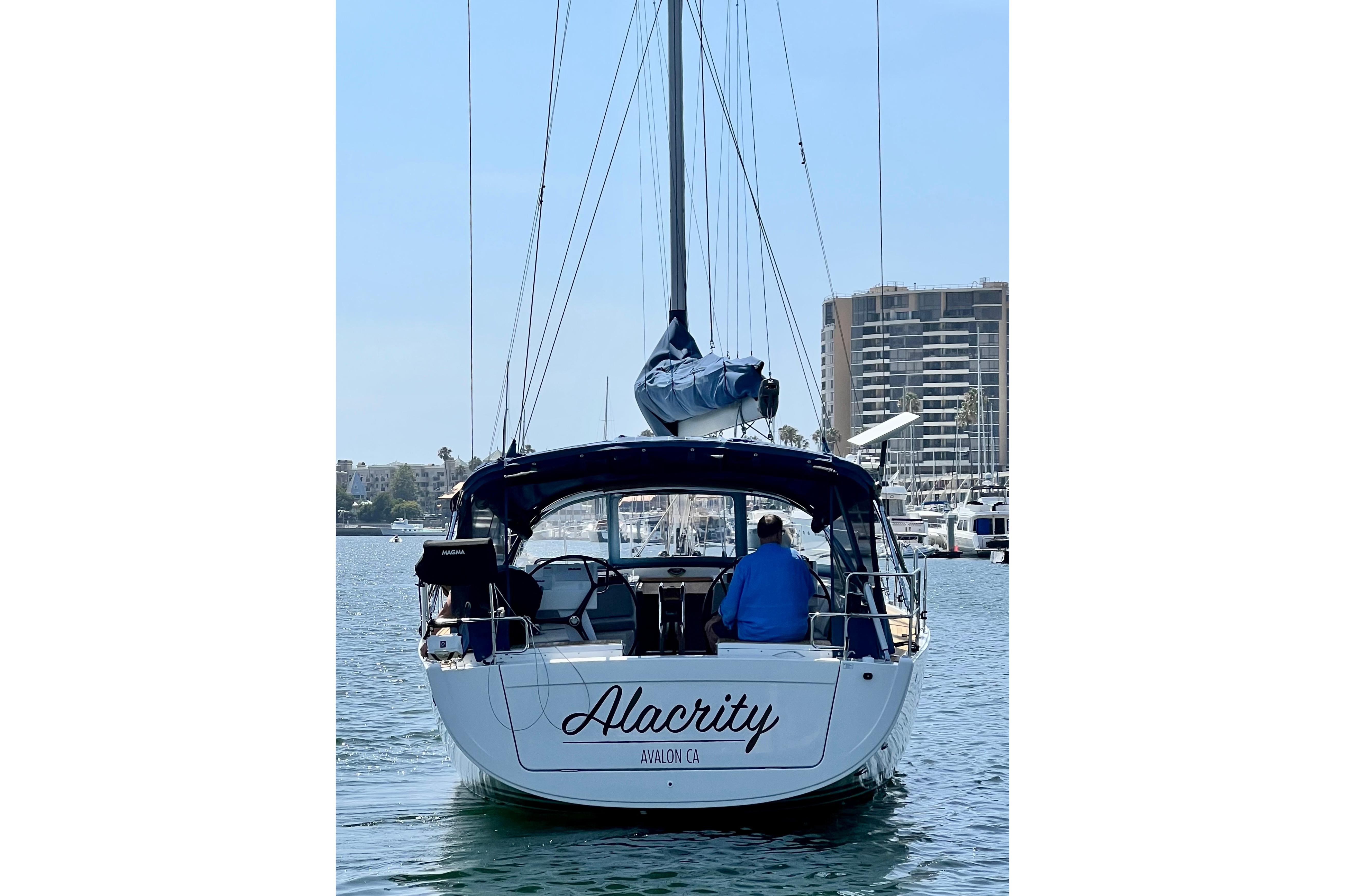 Sailboat Hanse 455 (2016) named Alacrity in marina, cityscape background.