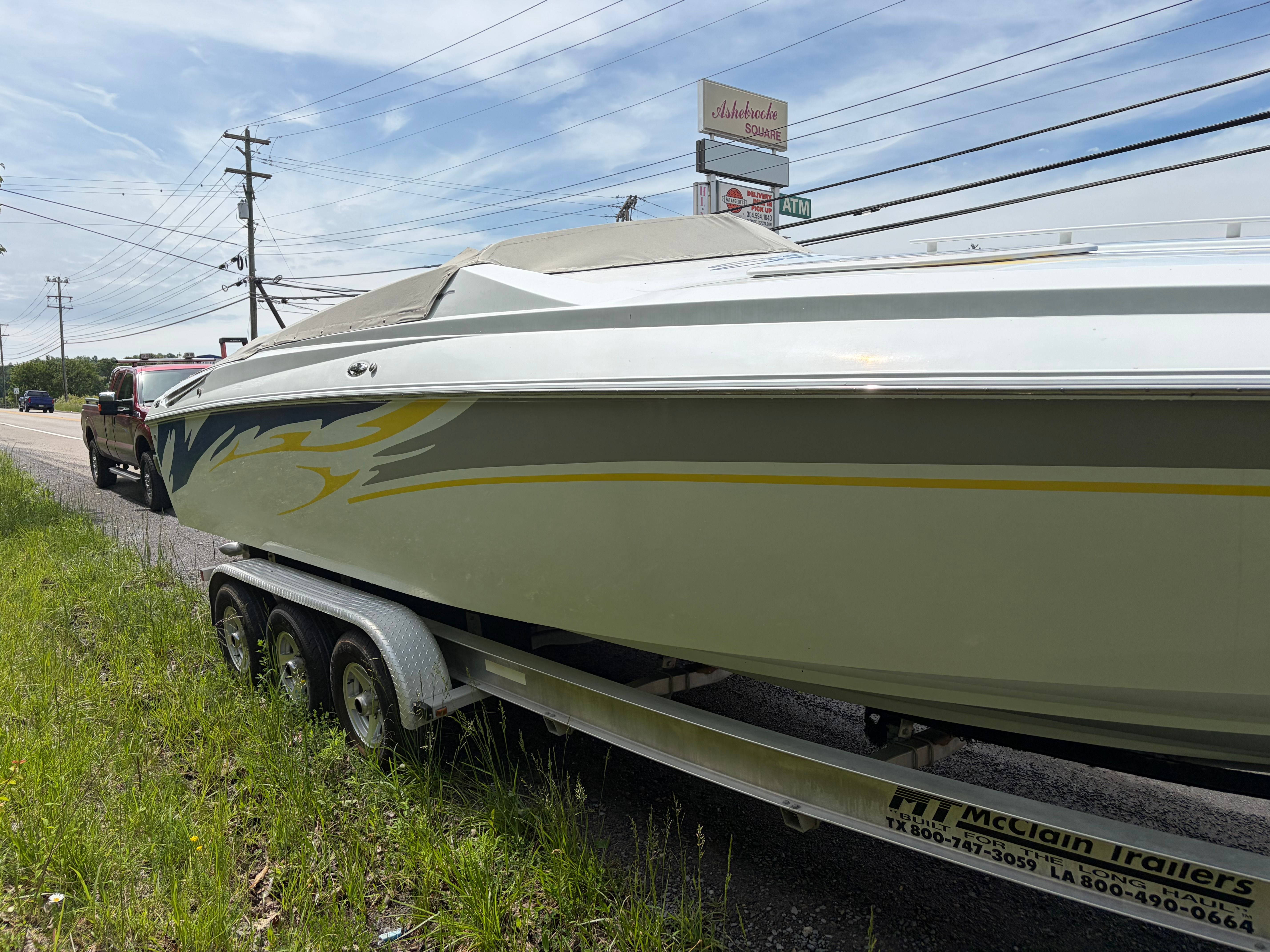2007 Baja 30 Outlaw boat on trailer by roadside.