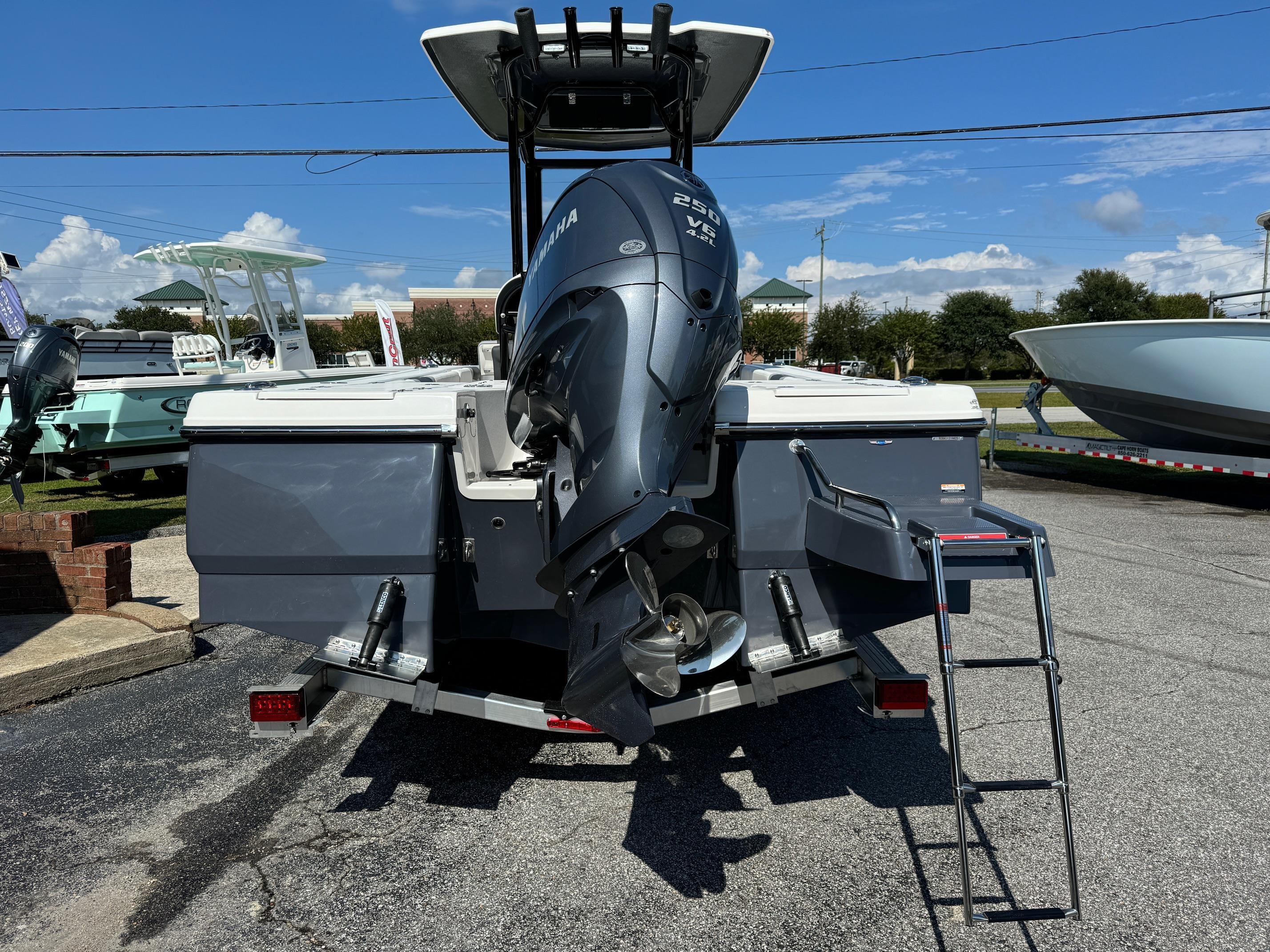 2025 Robalo R246 CAYMAN boat with Yamaha outboard motor and ladder, parked outdoors.