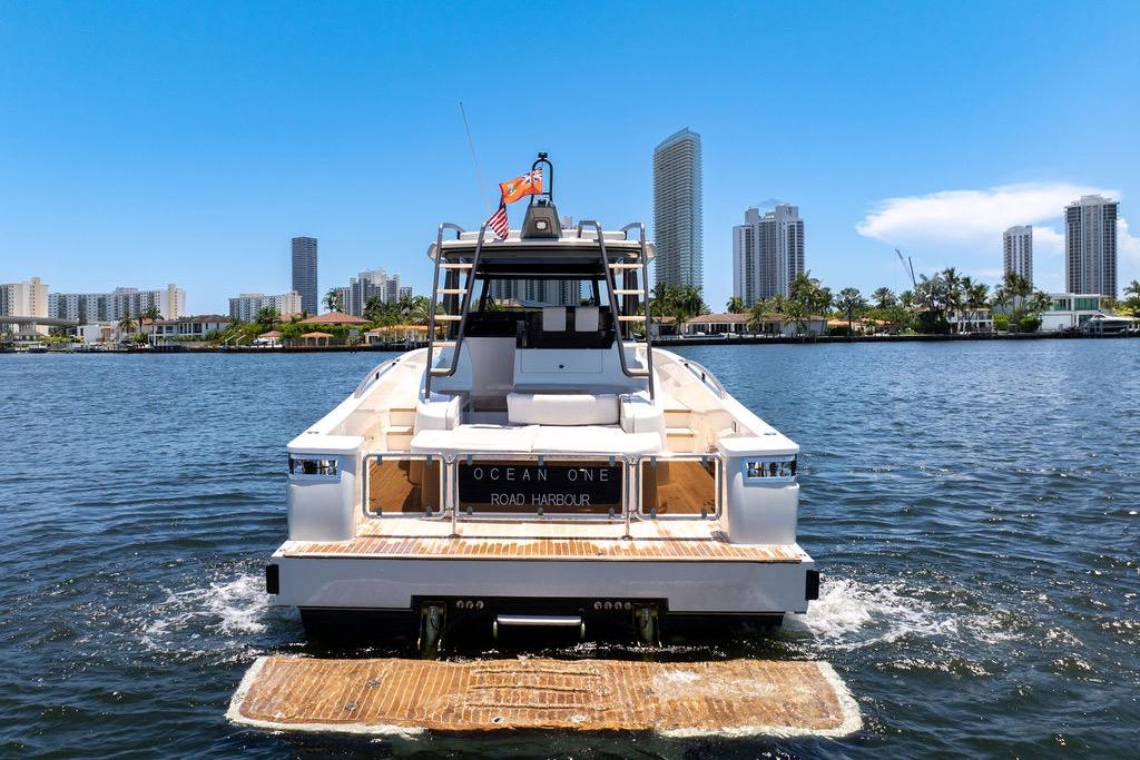 2021 Bluegame BG 42 yacht on water with city skyline backdrop.
