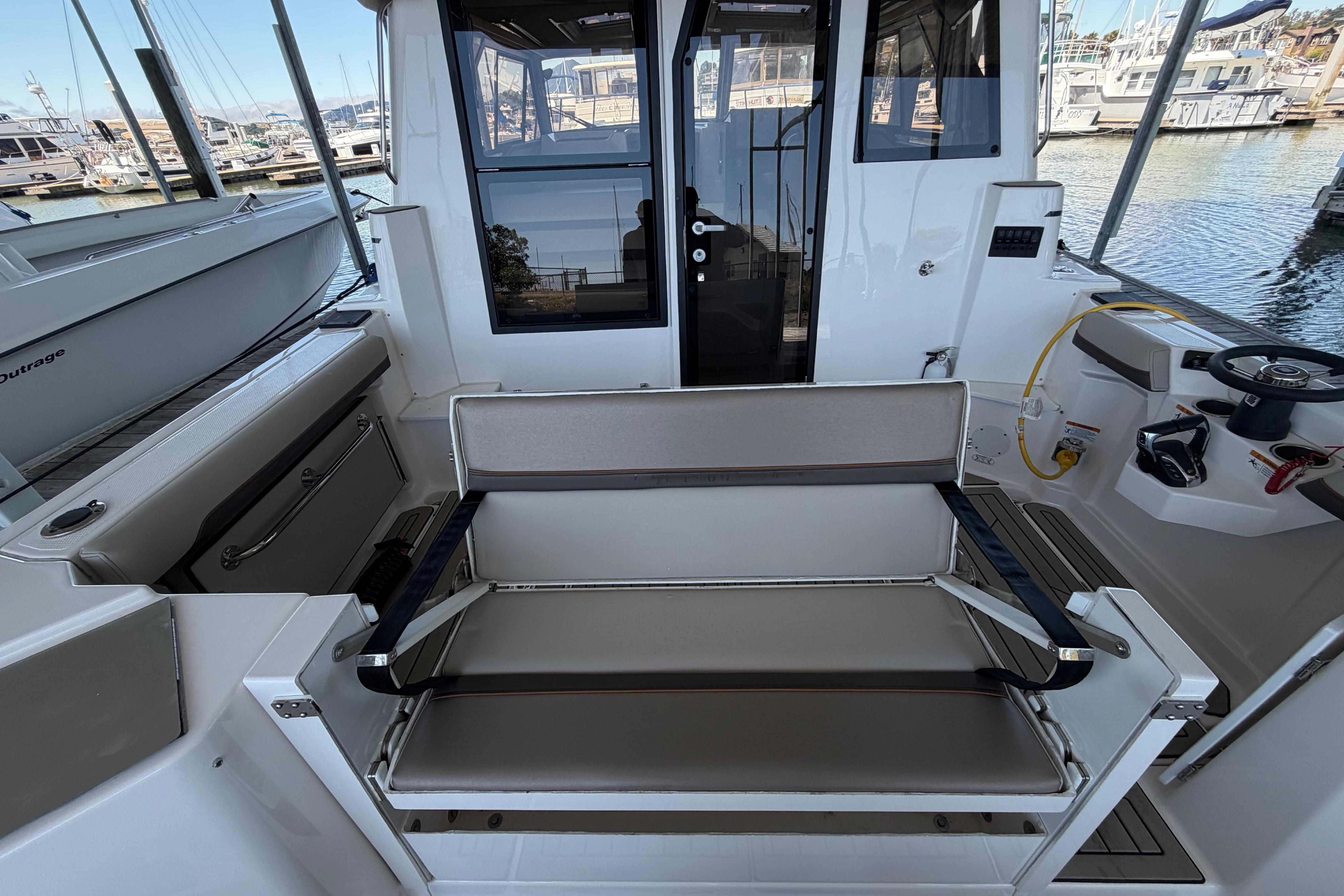 2023 Cutwater C-288 Coupe cockpit with seating, steering wheel, and marina view.