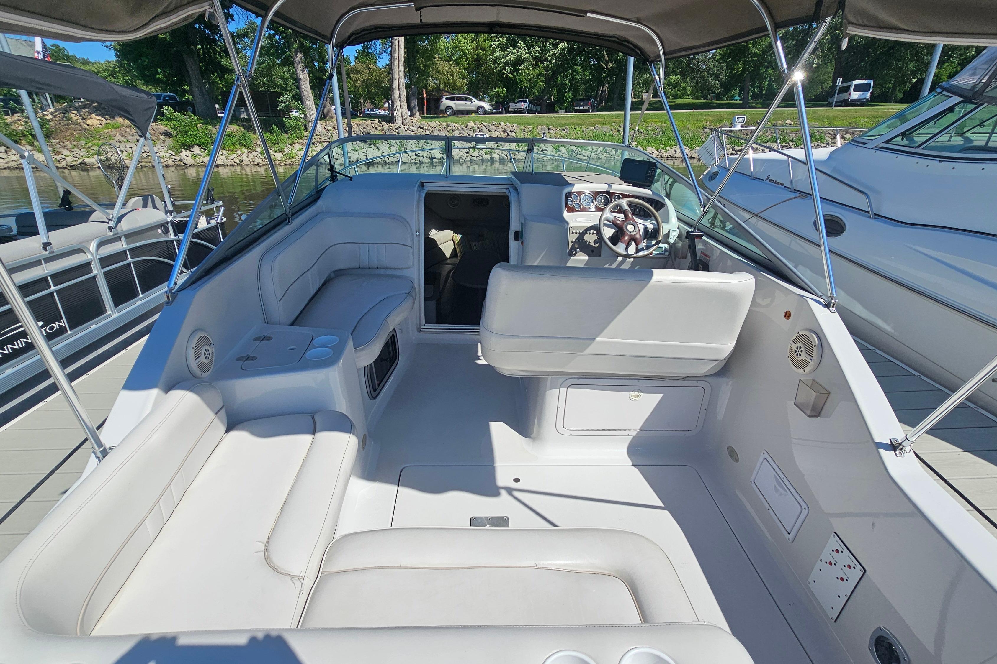 2000 Crownline 242 CR boat interior with seating, steering wheel, and canopy.