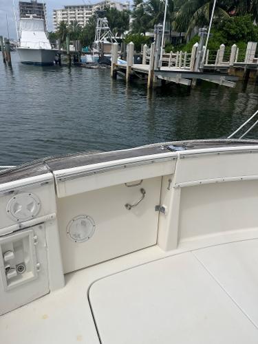1985 Hatteras 45 Convertible yacht docked at marina, featuring spacious deck and waterfront view.