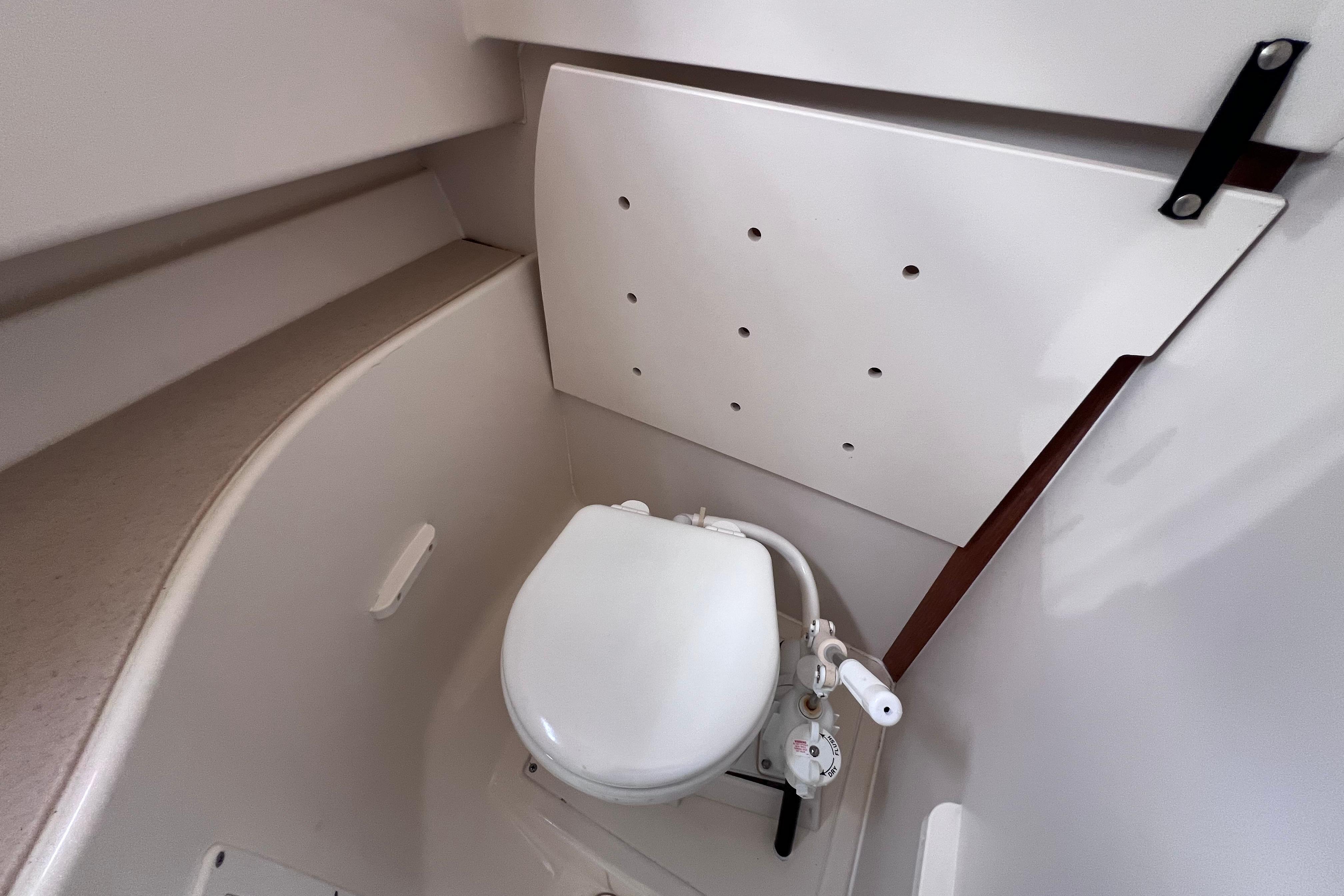 Compact marine toilet in 2004 Pursuit 2870 Walkaround boat cabin.