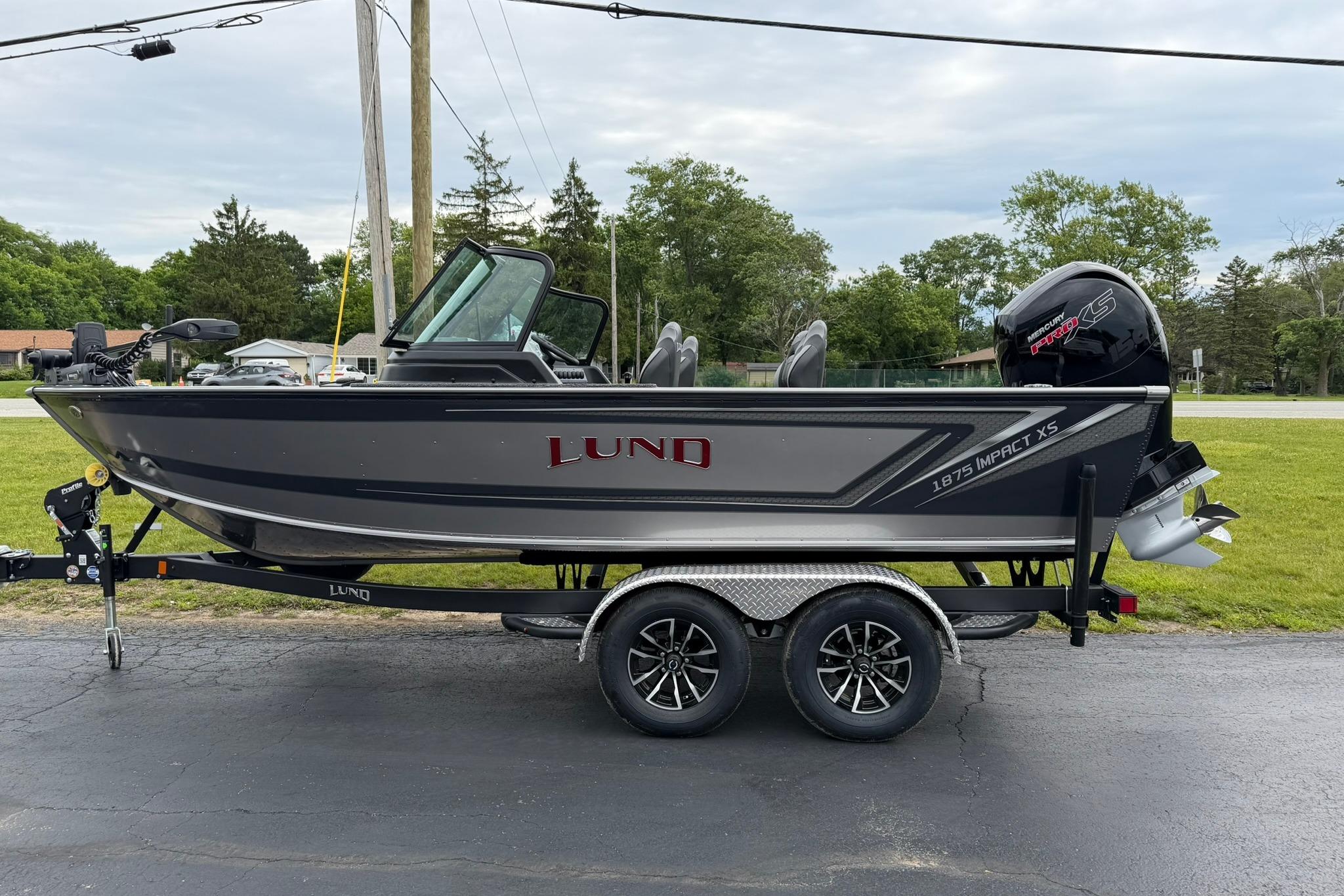 2027 Lund 1875 Impact XS Sport boat on trailer, parked outdoors.