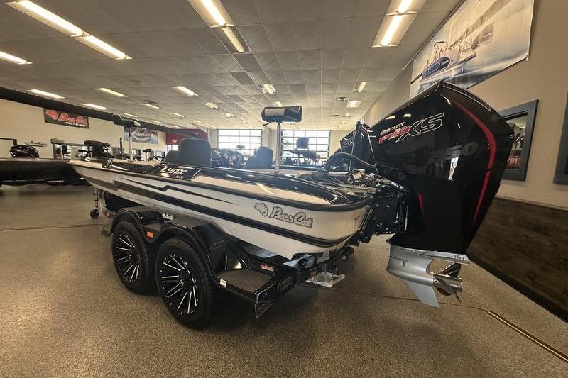 2026 Bass Cat Lynx STS boat in showroom, featuring sleek design and powerful engine.